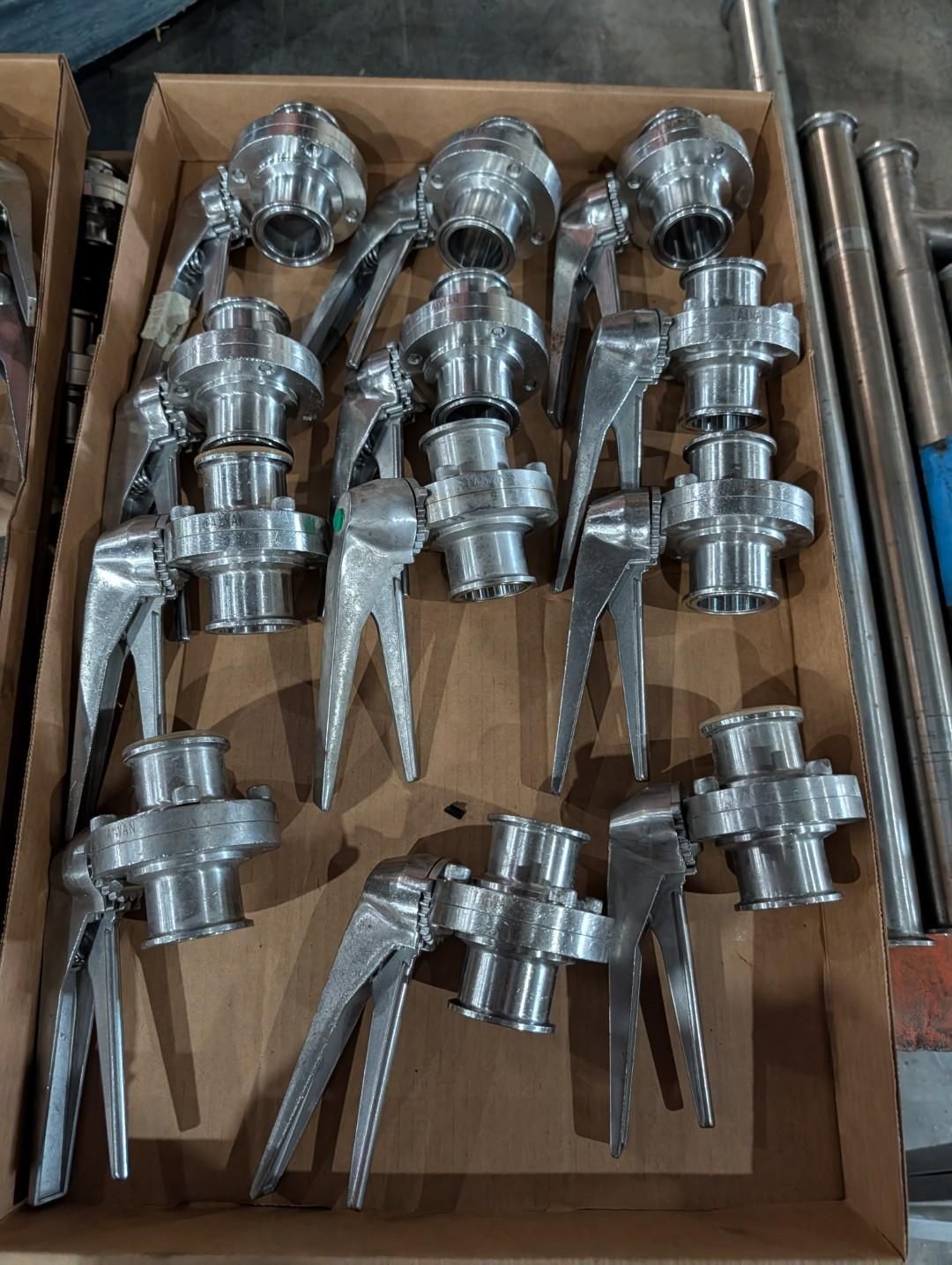 Box of shiny metal latch hardware arranged in cardboard trays