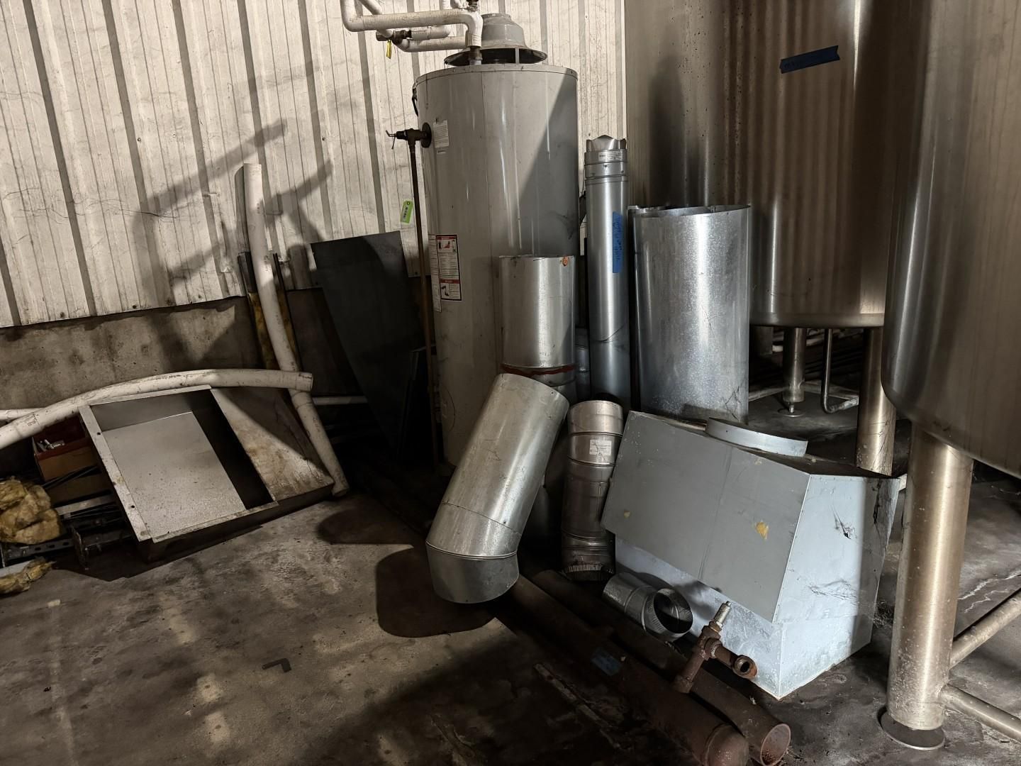 Industrial metal tanks and ducts in a utility room with a concrete floor