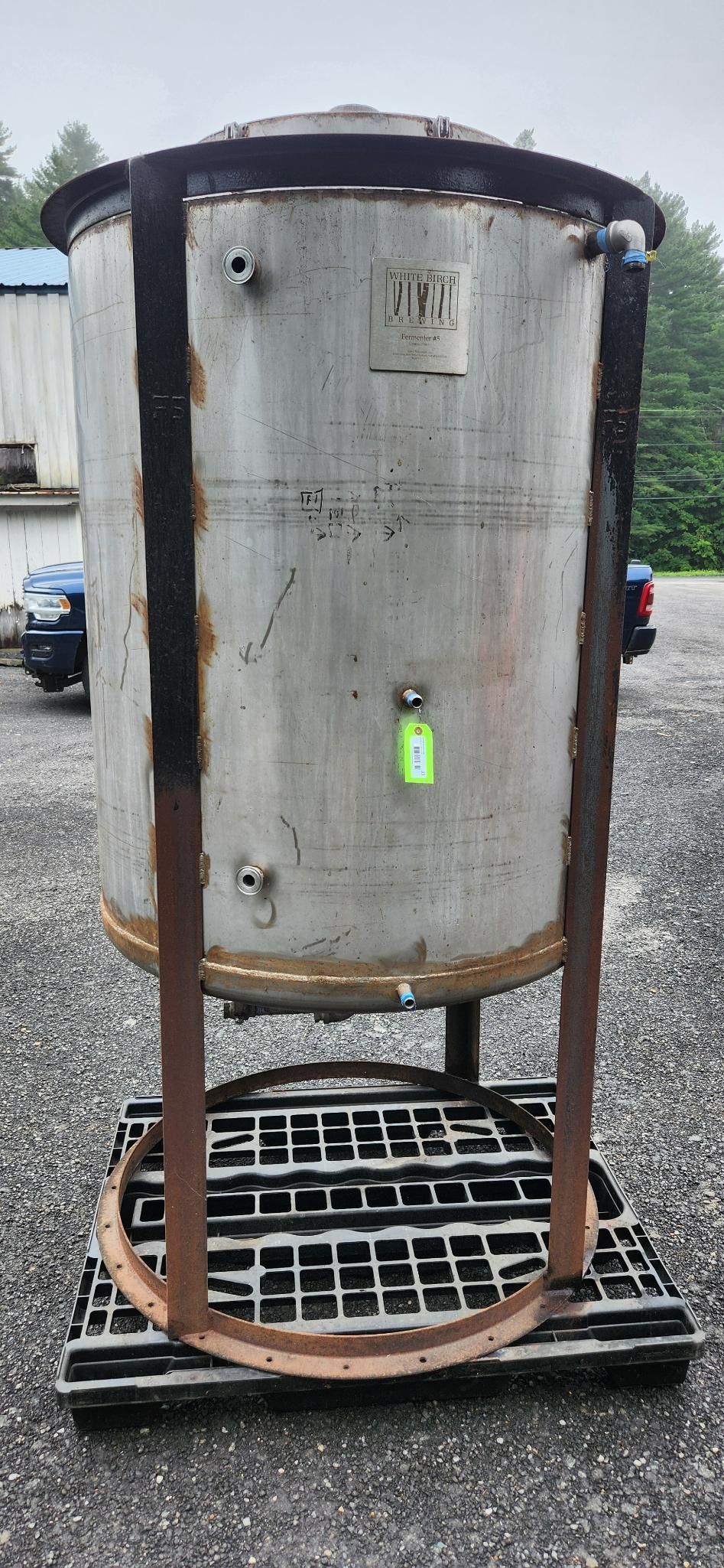 Large cylindrical metal tank on a stand with a black base outdoors