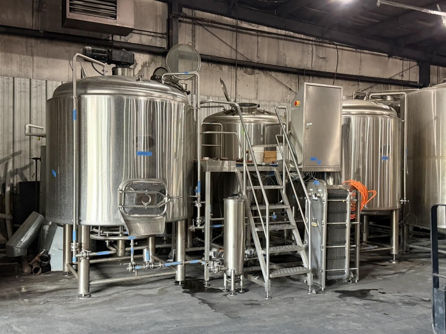 Stainless steel industrial tanks and piping in a brewery or food-processing facility