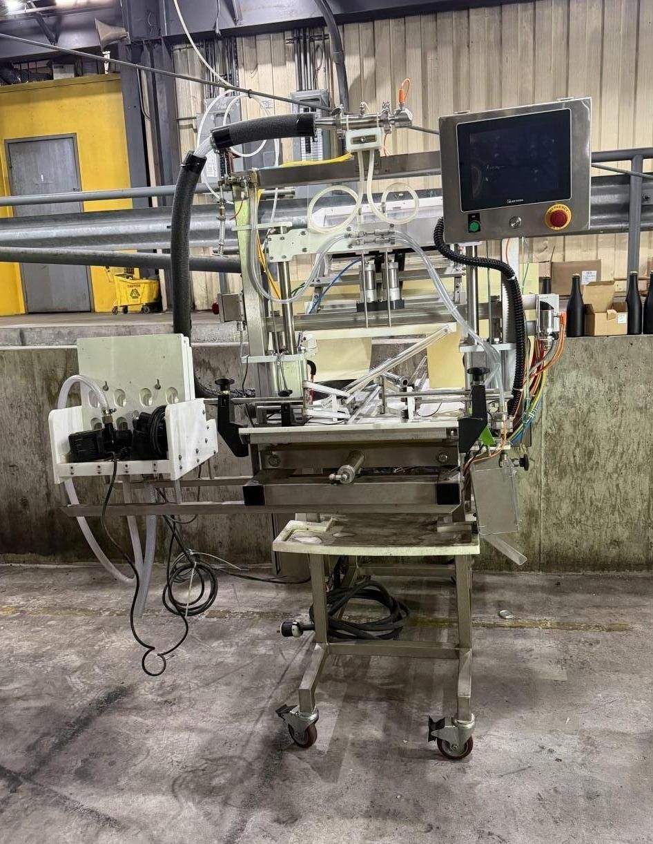 Industrial machine on wheels with a monitor, wiring, and metal components in a factory setting
