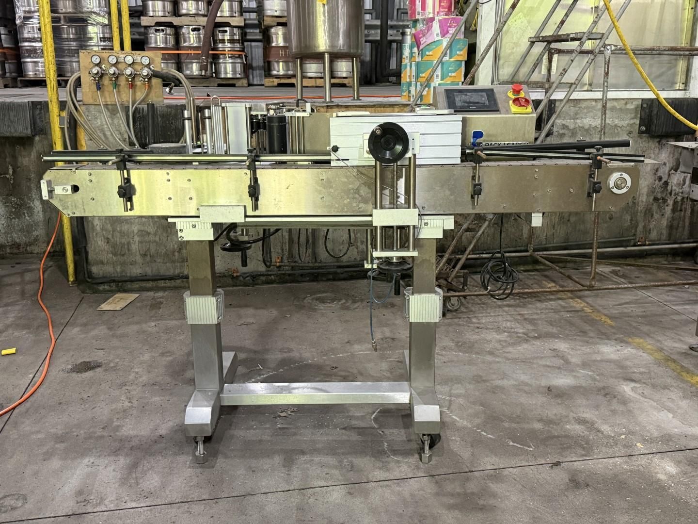 Stainless steel conveyor belt on a wheeled stand in an industrial workshop