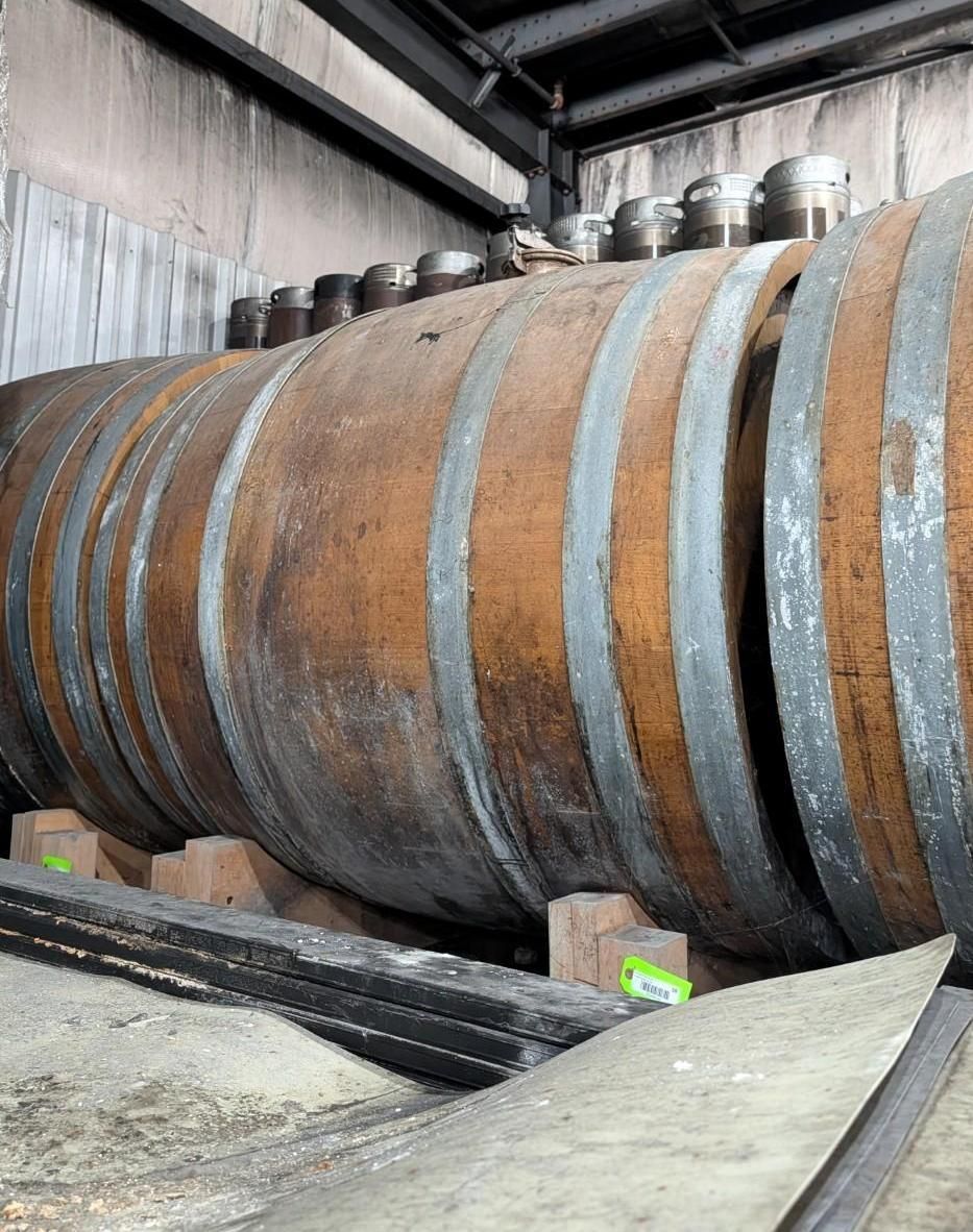 Large cylindrical industrial tank lying inside a warehouse-like facility, with metal bands around it.