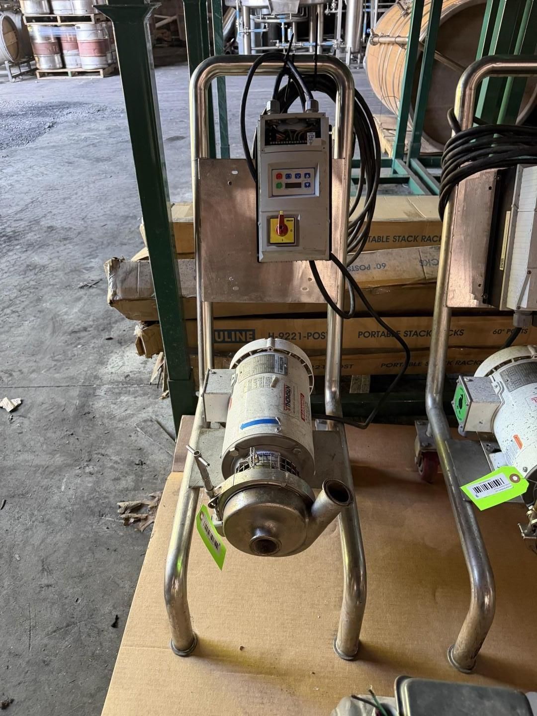 Industrial motor on a wheeled cart beside a control panel in a warehouse setting