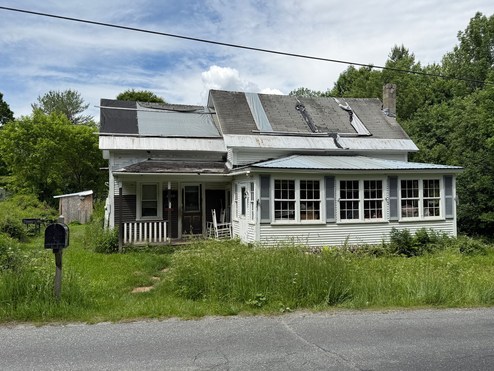house with roof,  yard, and  windows under a cloudy sky