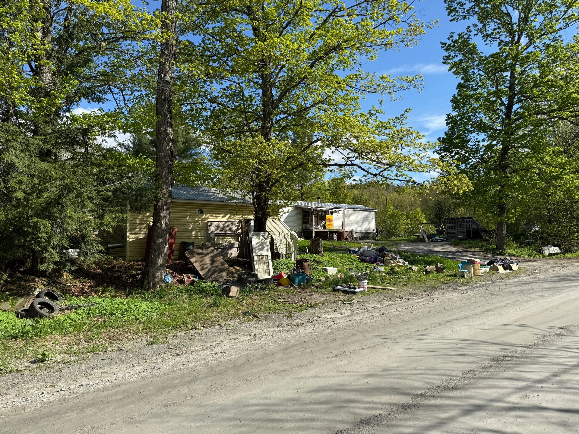 House amidst trees and a dirt road.