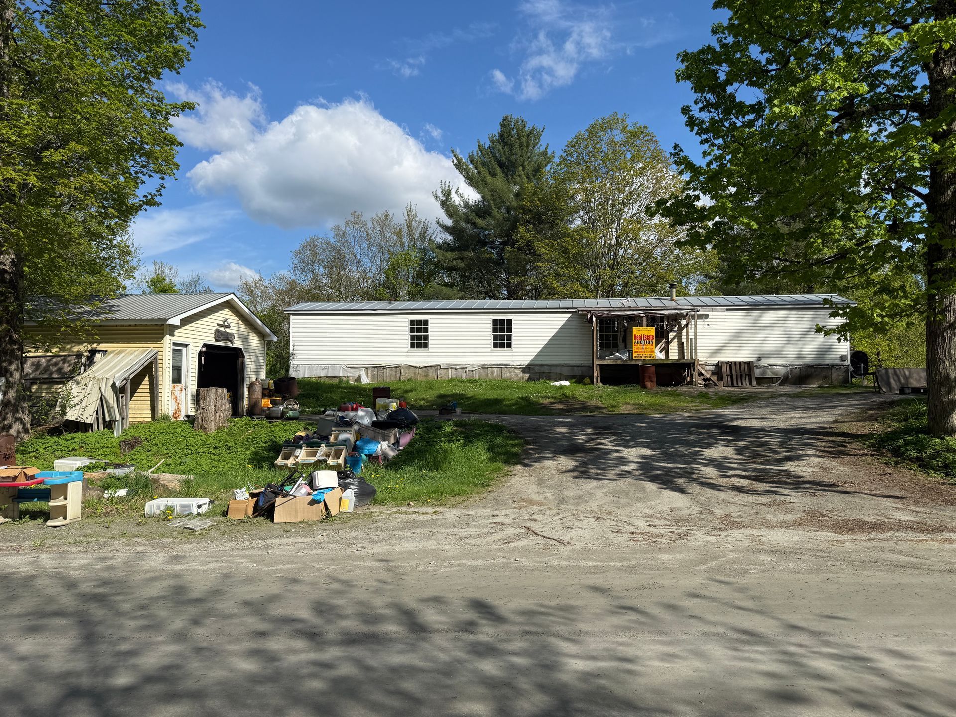 Mobile home and shed on a gravel lot.