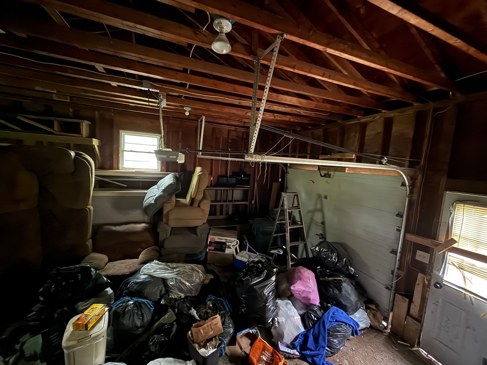 Interior of garage with furniture, and a pull-down ladder.