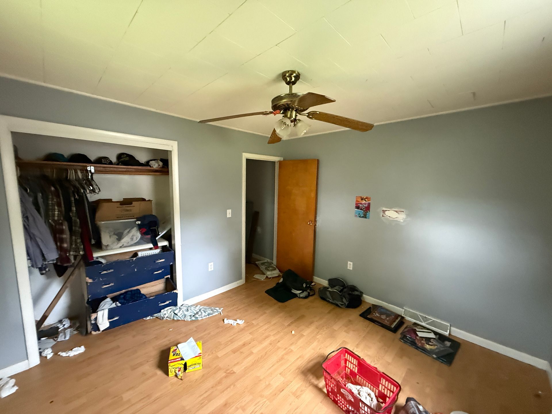 Bedroom with closet, gray walls, and ceiling fan.