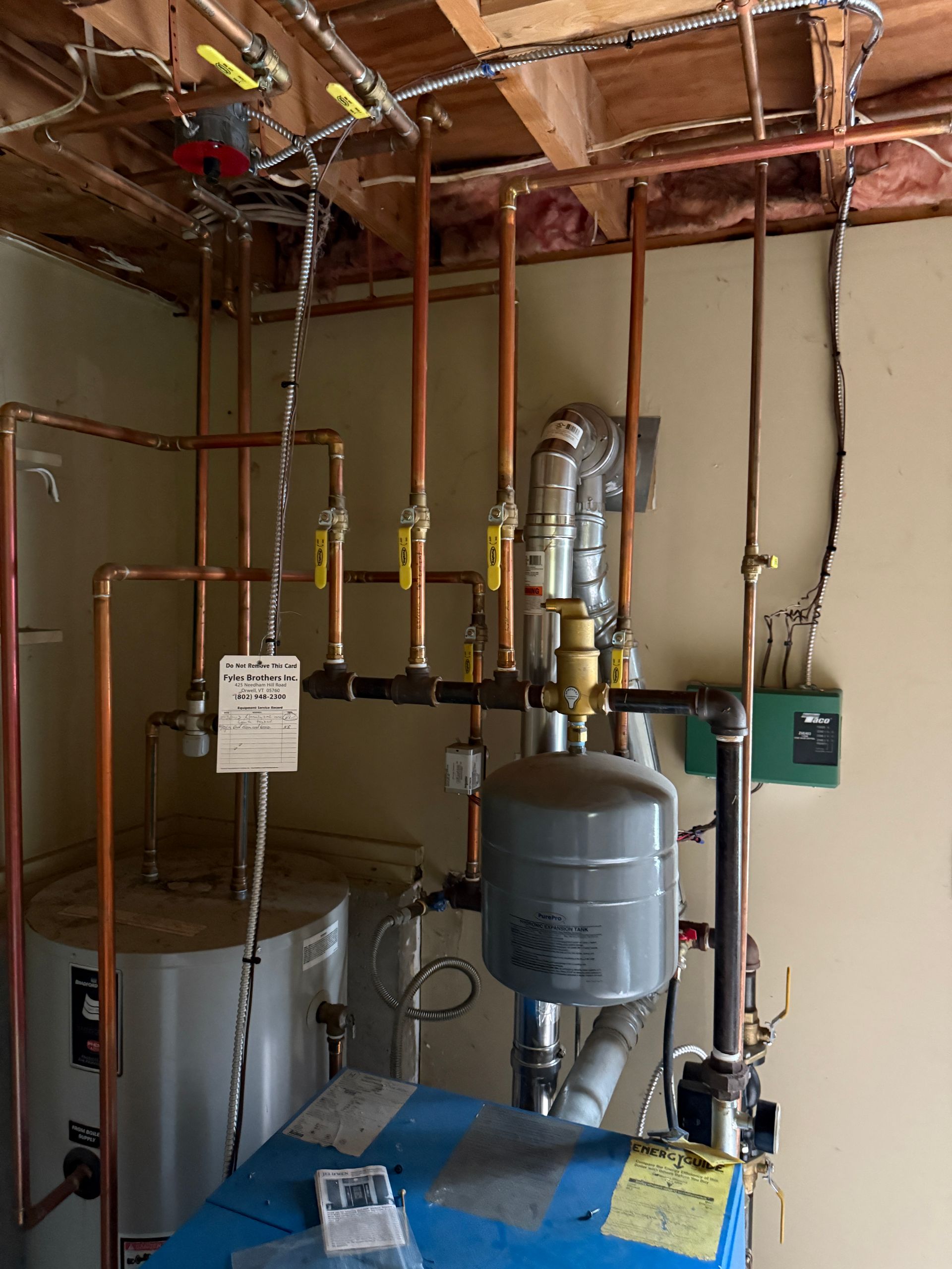 Copper pipes and valves, water heater, boiler, expansion tank in utility room.
