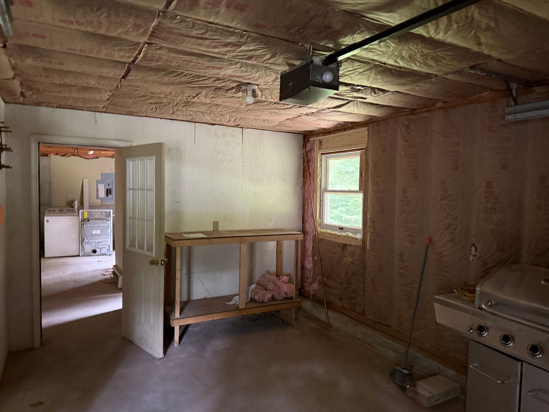 Interior of a room with ceiling and walls, a window, and a grill.