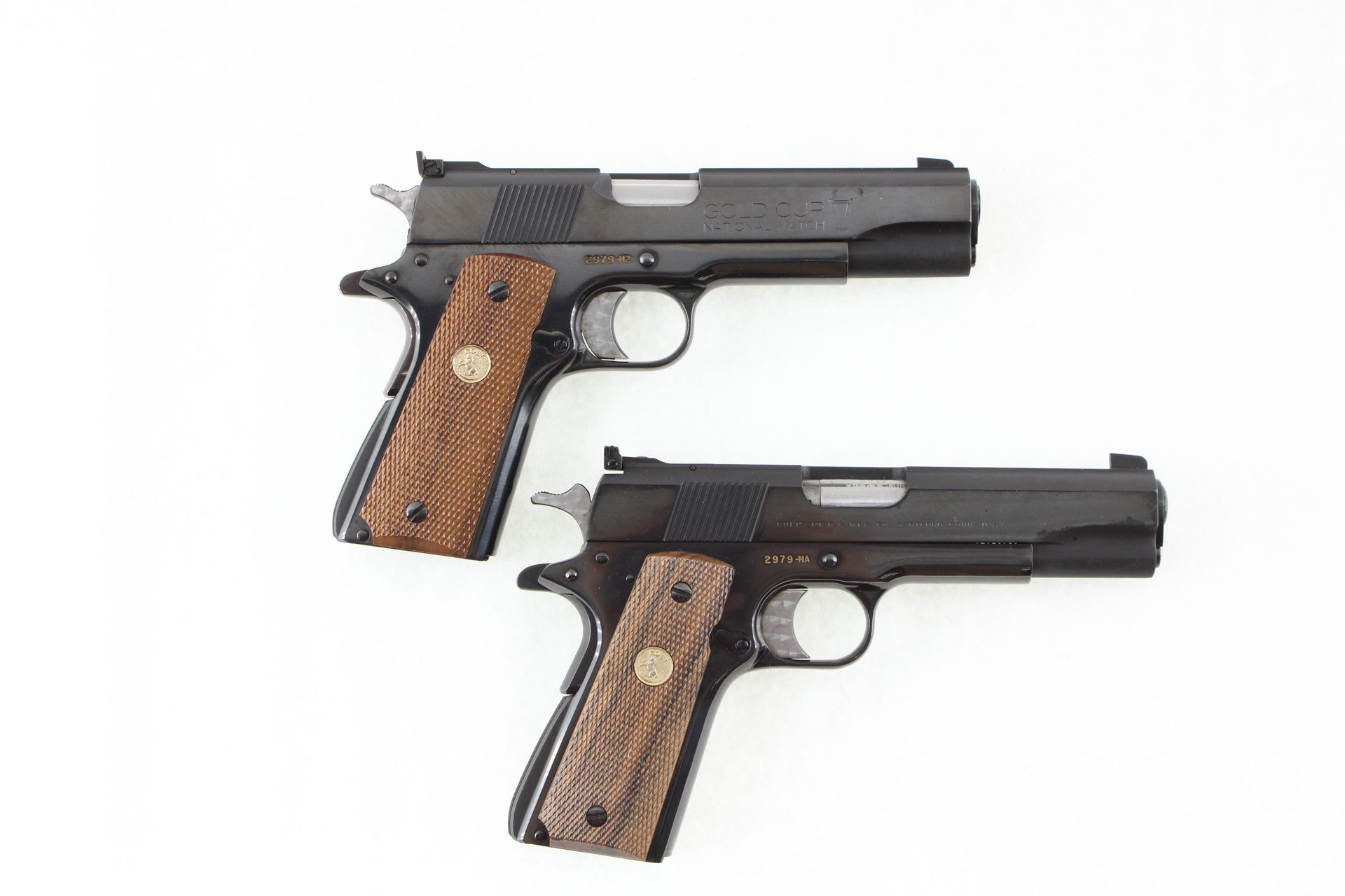 Two black handguns with wooden grips on a white background.