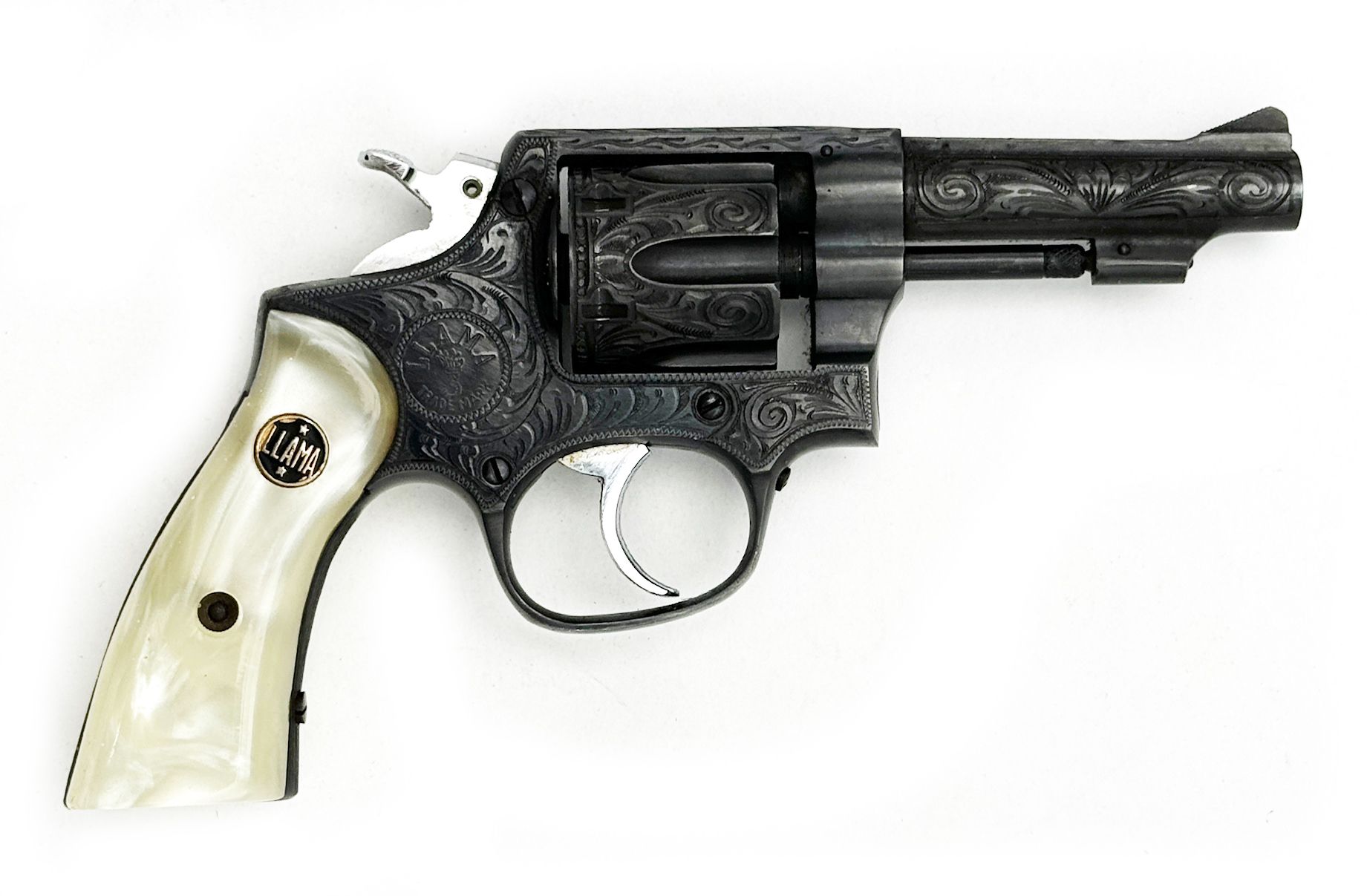 Engraved revolver with ivory grips, resting on a white surface.