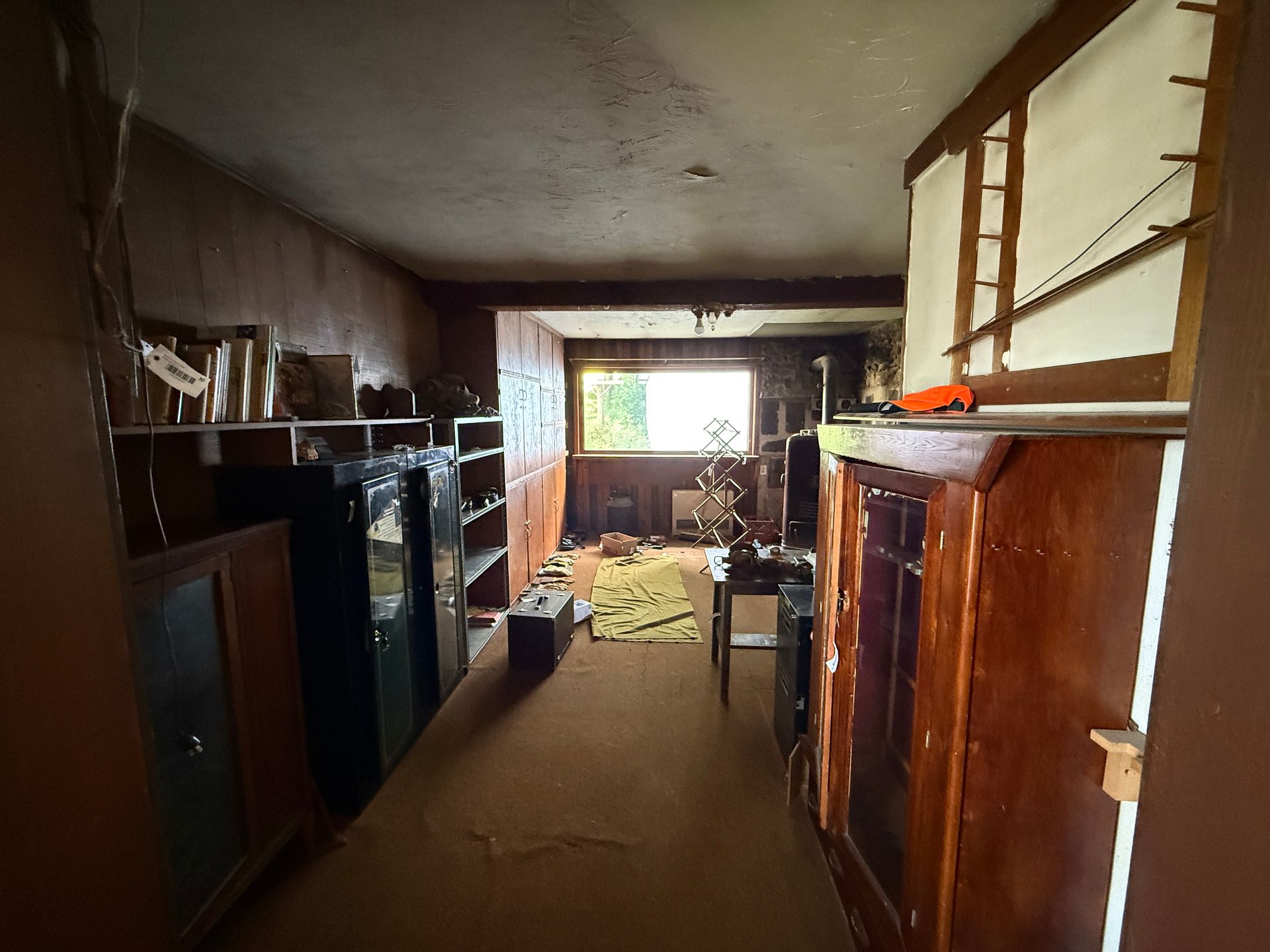 Interior view of a room with furniture, shelves, and a window.