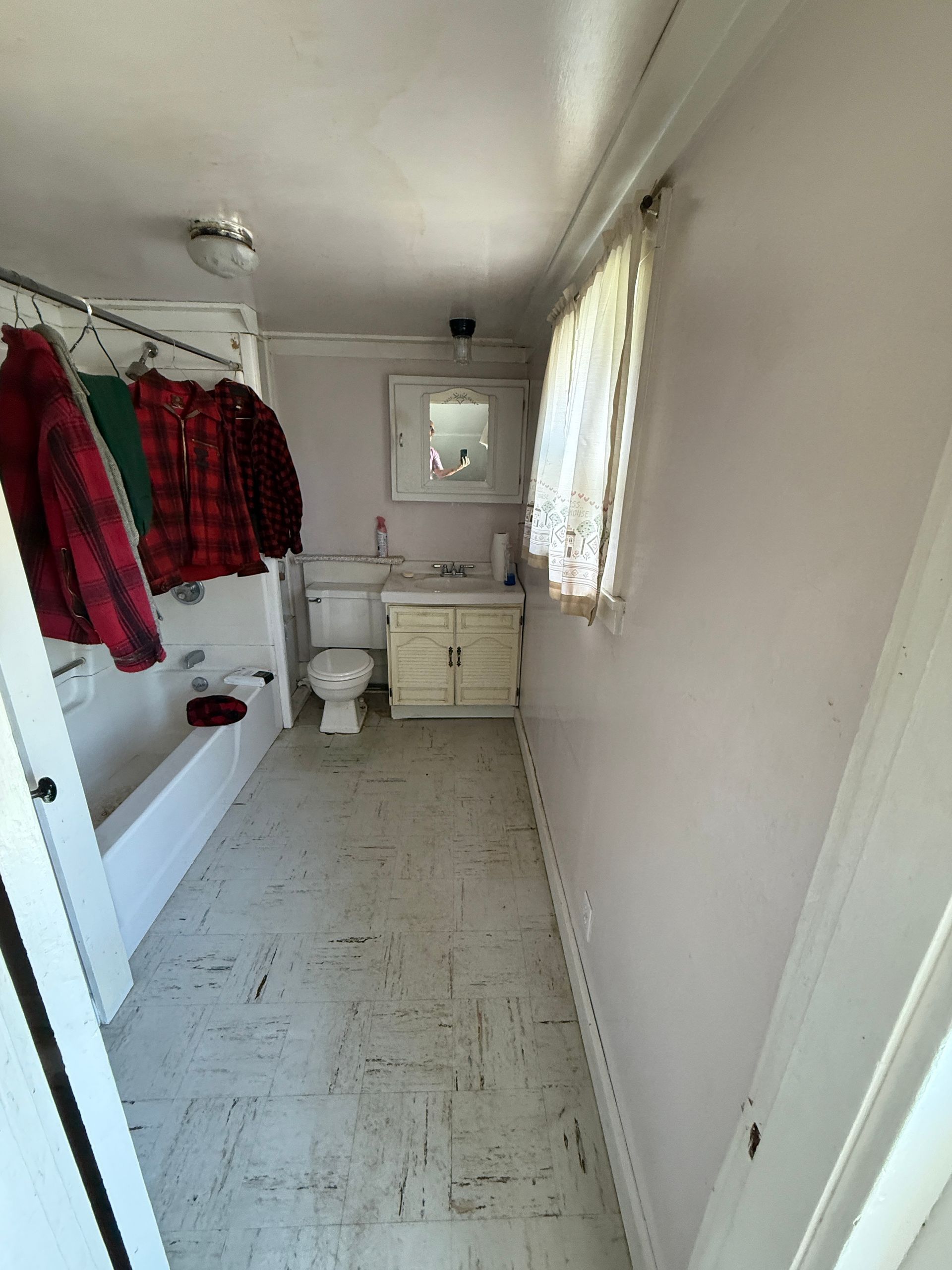 Small bathroom with a tub, toilet, and vanity.
