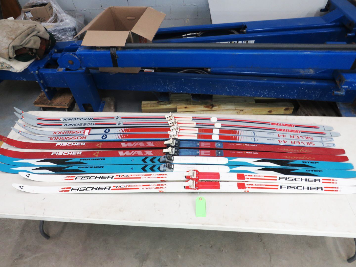 Rows of cross-country skis on a table, various colors, brands 