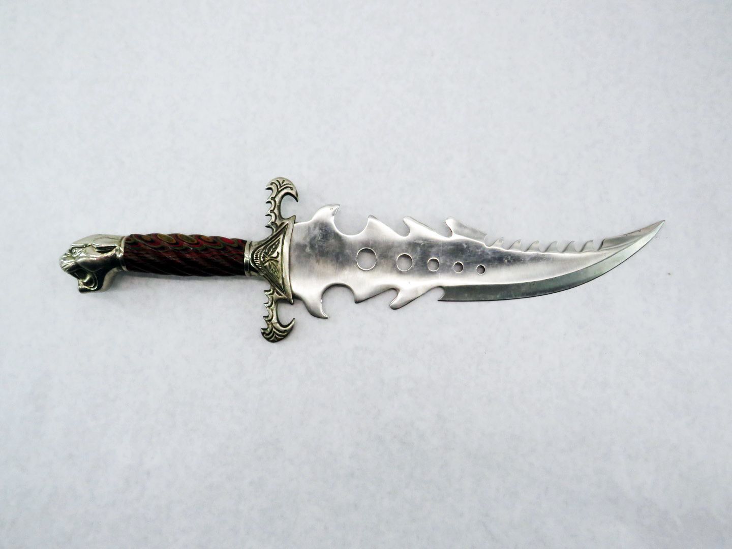Decorative silver dagger with brown wrapped handle and a skull pommel.