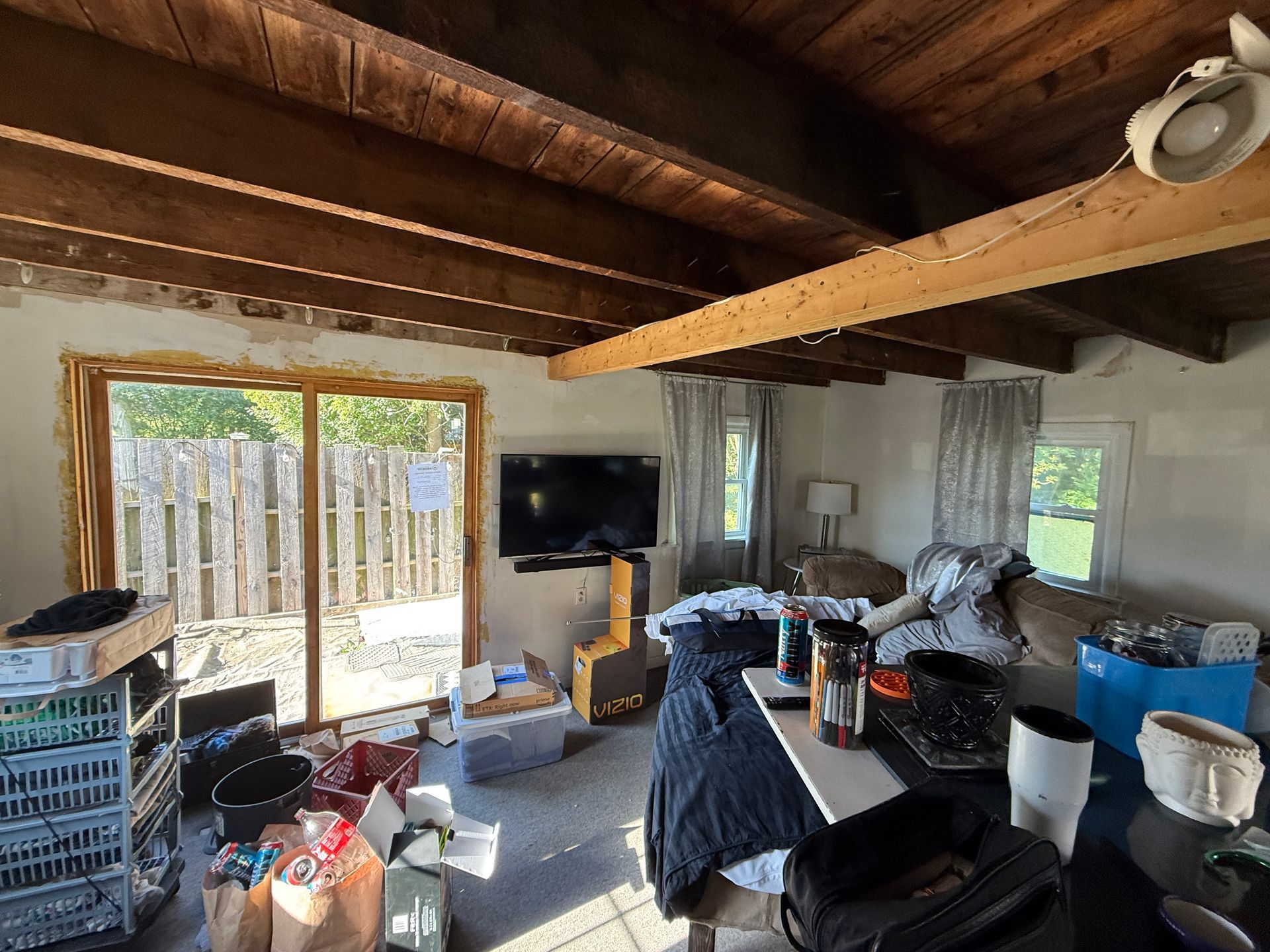 Living room with a sliding door and exposed ceiling beams.