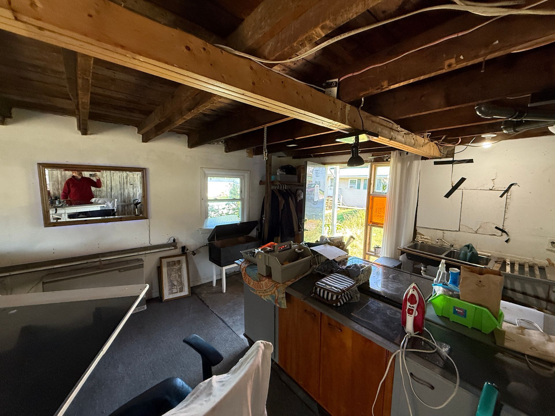 Interior room with exposed beams, with a mirror and sliding glass door.