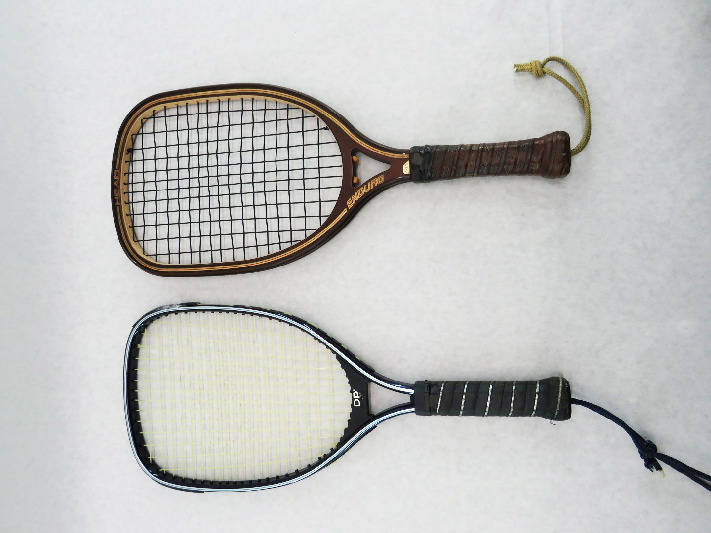 Two vintage rackets: wooden frame with string mesh above, and a modern one below.