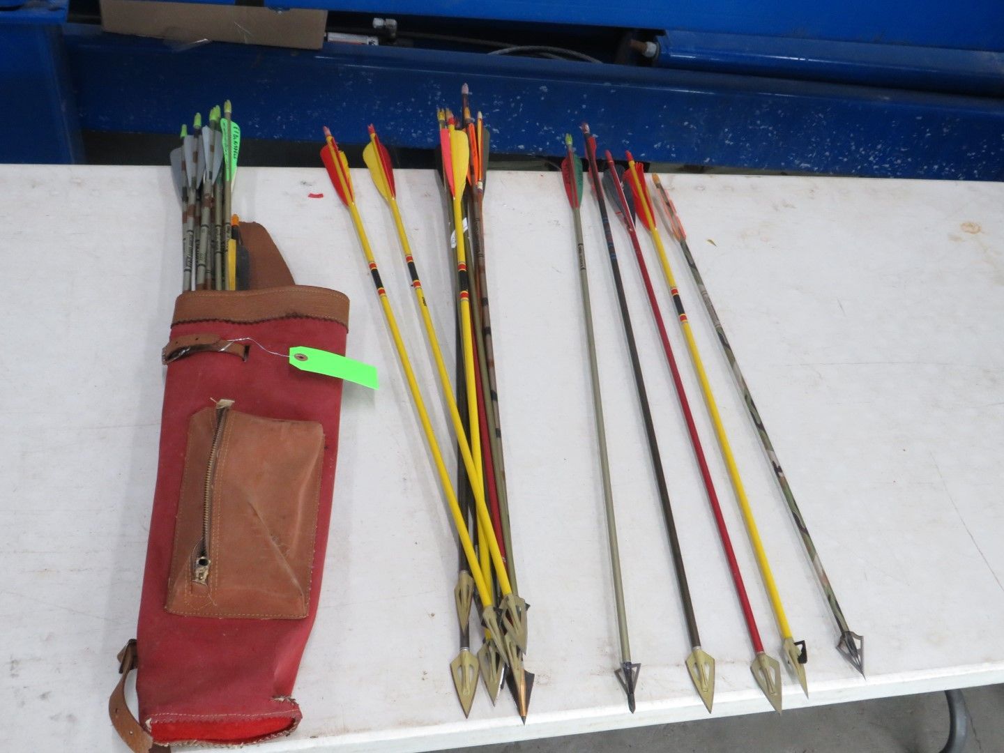 Arrows and a quiver on a white surface. The quiver is red, and the arrows are various colors.