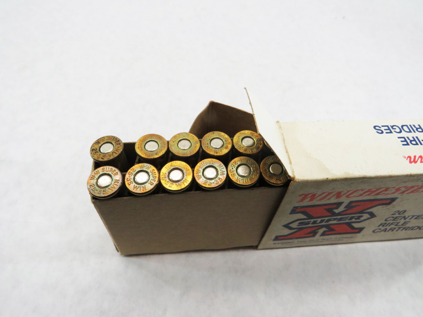 Box of Winchester Super X rifle cartridges, brass casings visible.