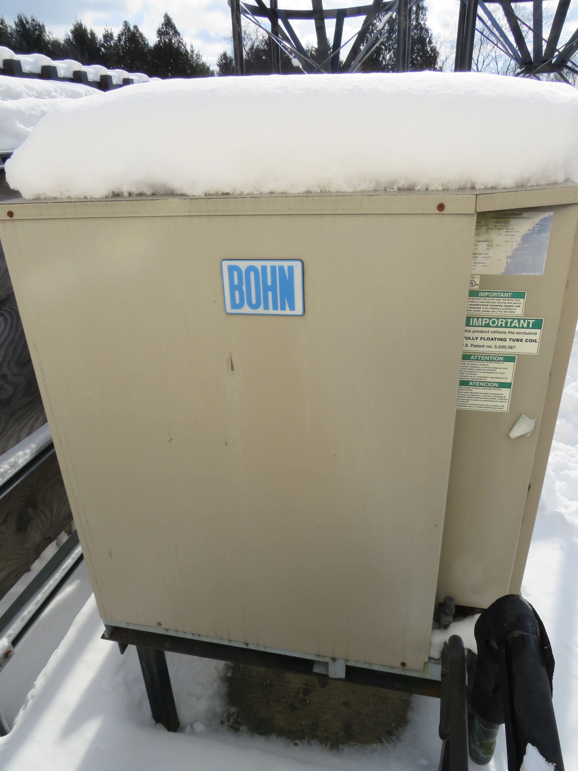 Tan Bohn industrial unit covered in snow, sitting on a metal frame, snowy background.
