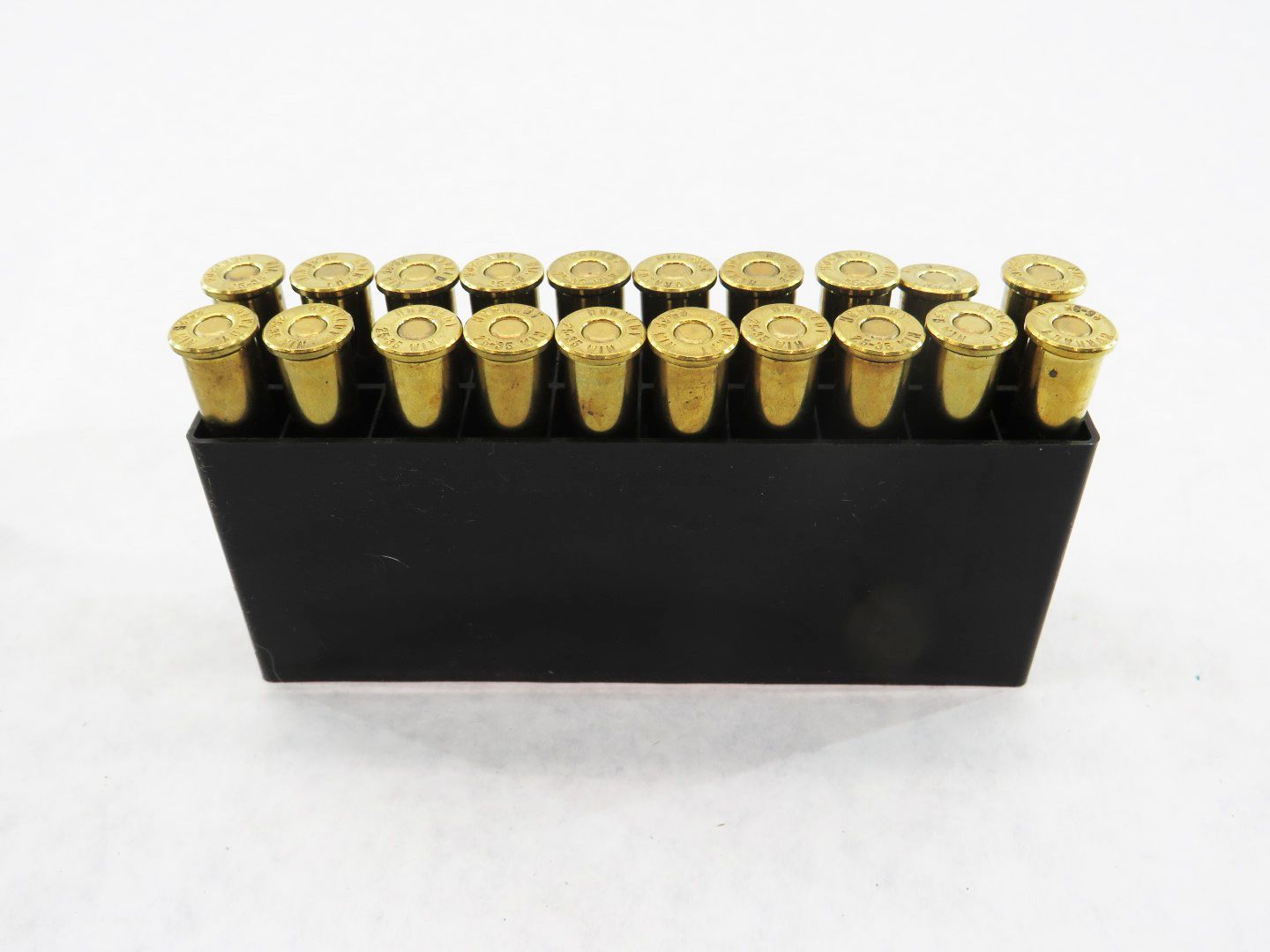 Cartridge ammunition in a black box, brass casings visible.
