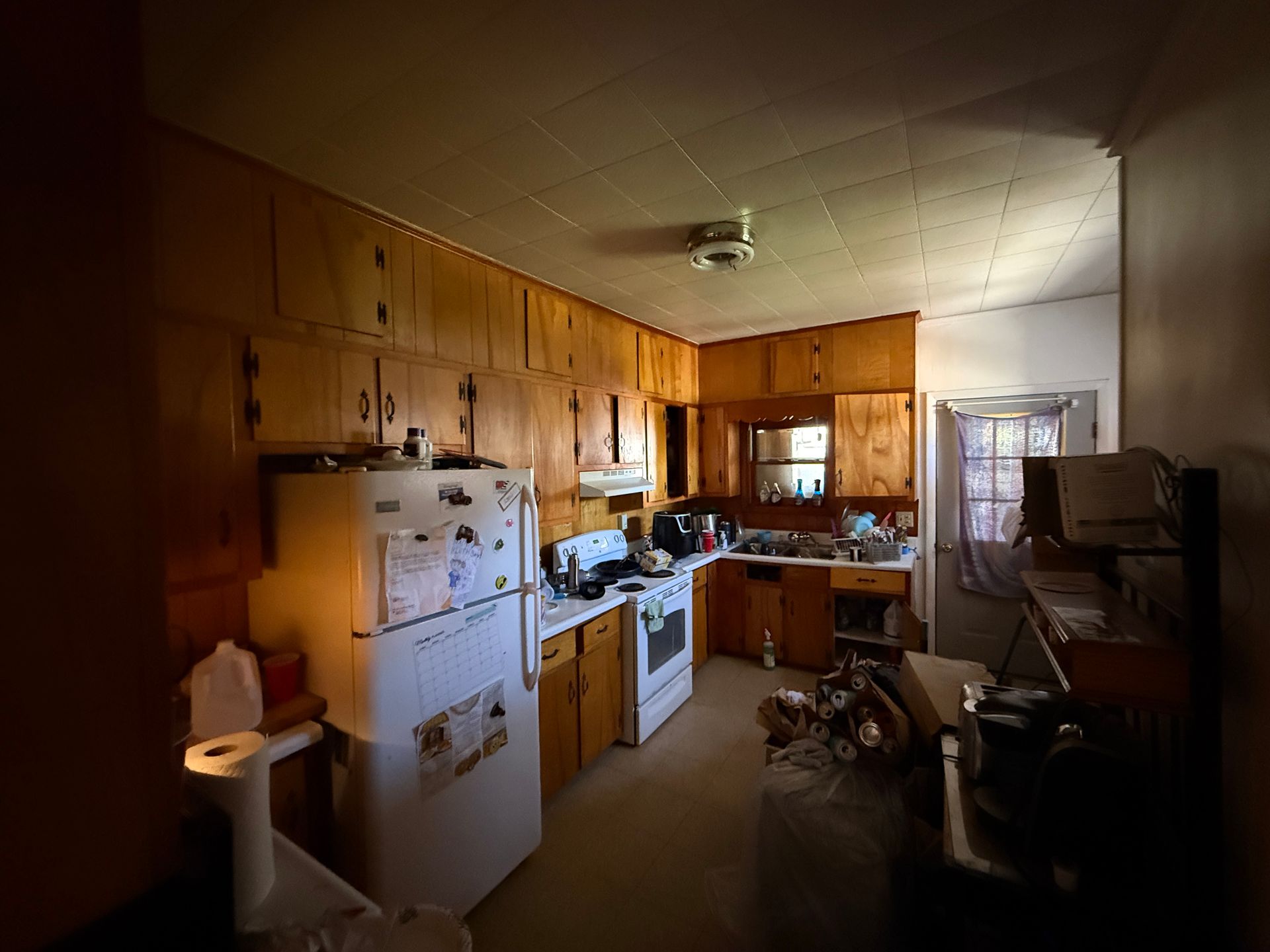 A kitchen with wooden cabinets, a white refrigerator, and various appliances.
