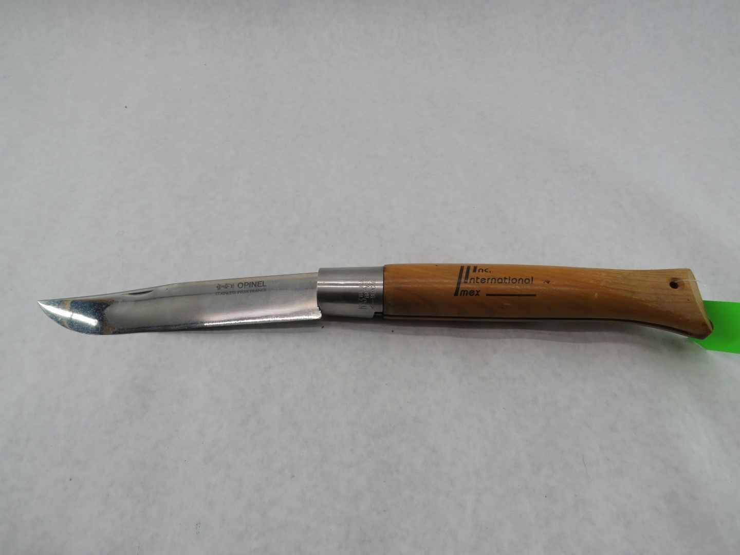 Pocket knife with a wooden handle, blade open, against a white backdrop.