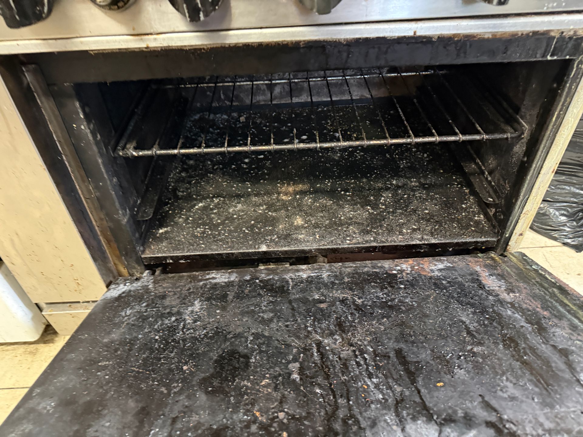 ODirty oven interior with two racks and open door.