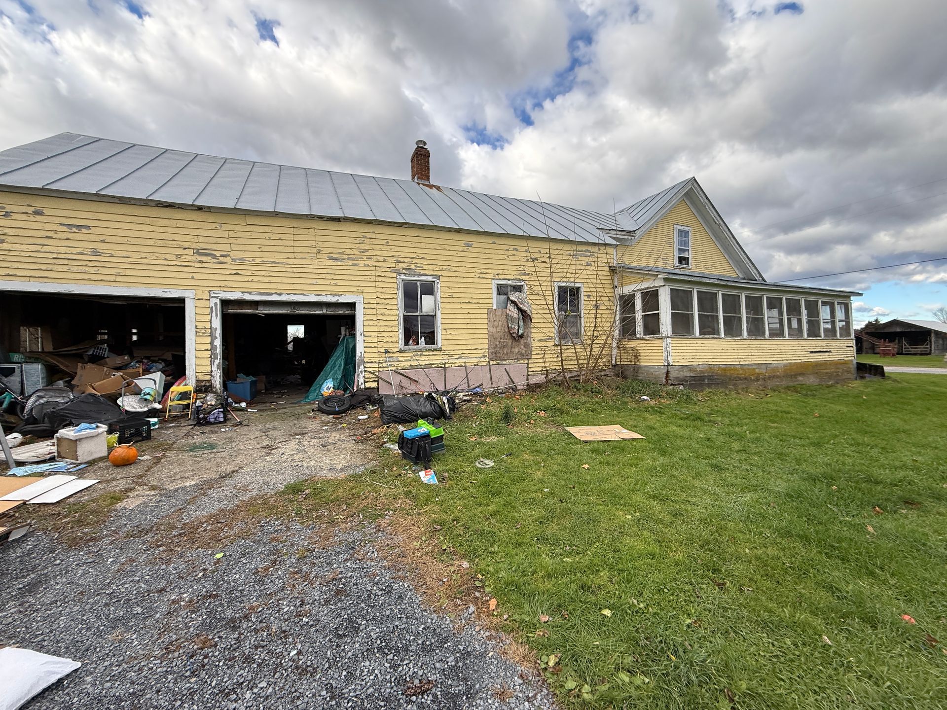 Yellow house with open garage.