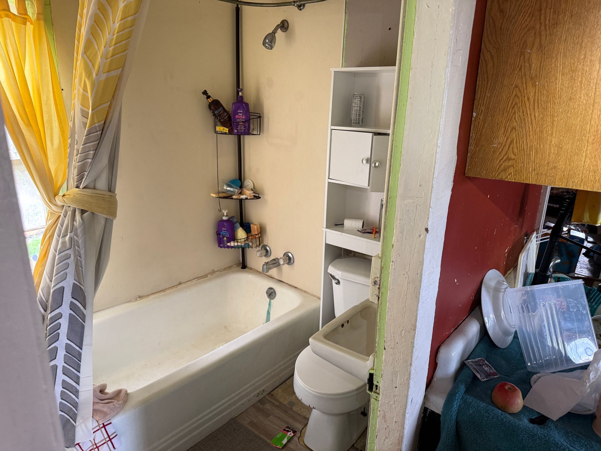 Bathroom with a white tub, toilet, and yellow shower curtain.