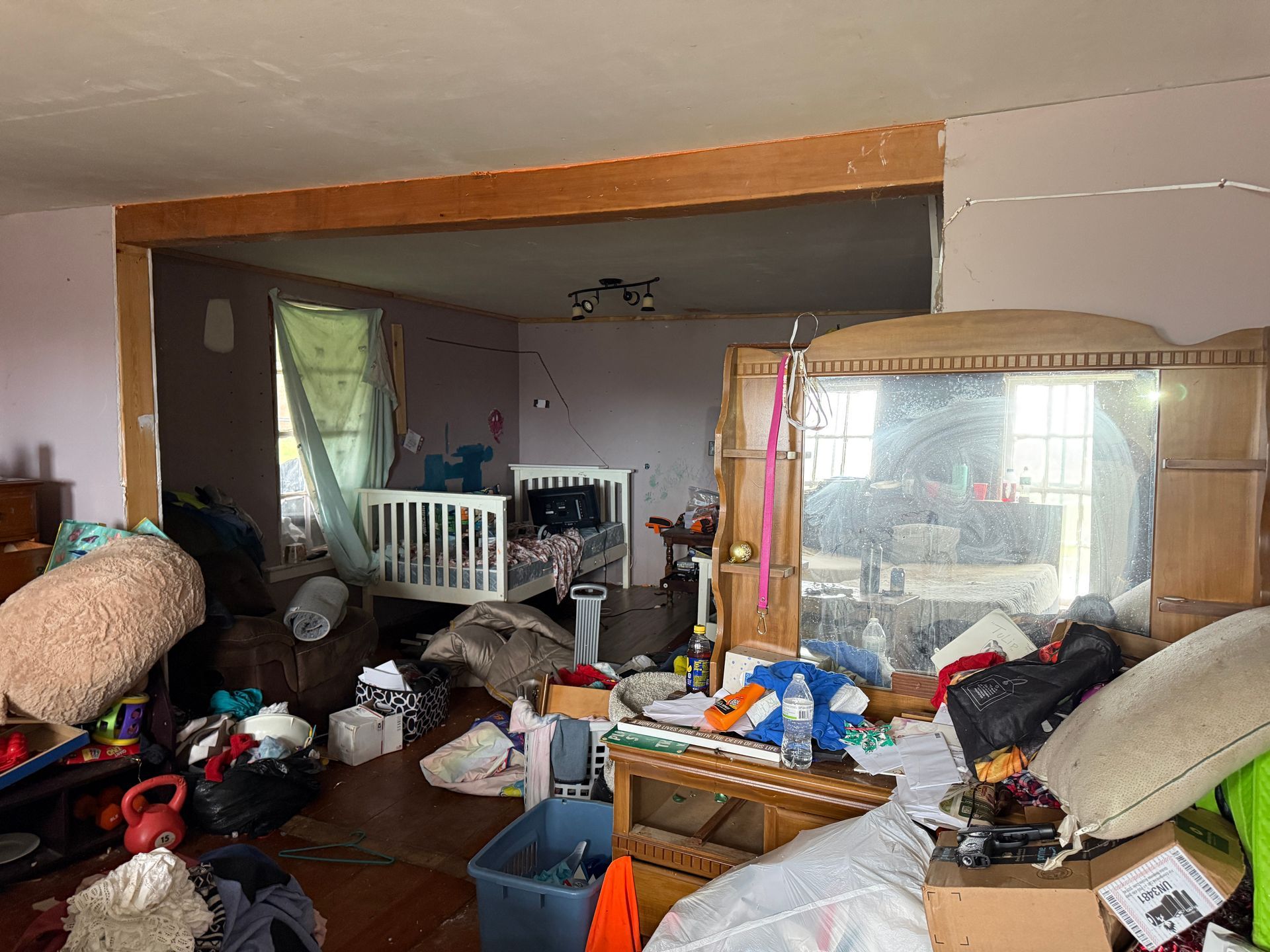 Room with furniture; a baby crib visible in the back.