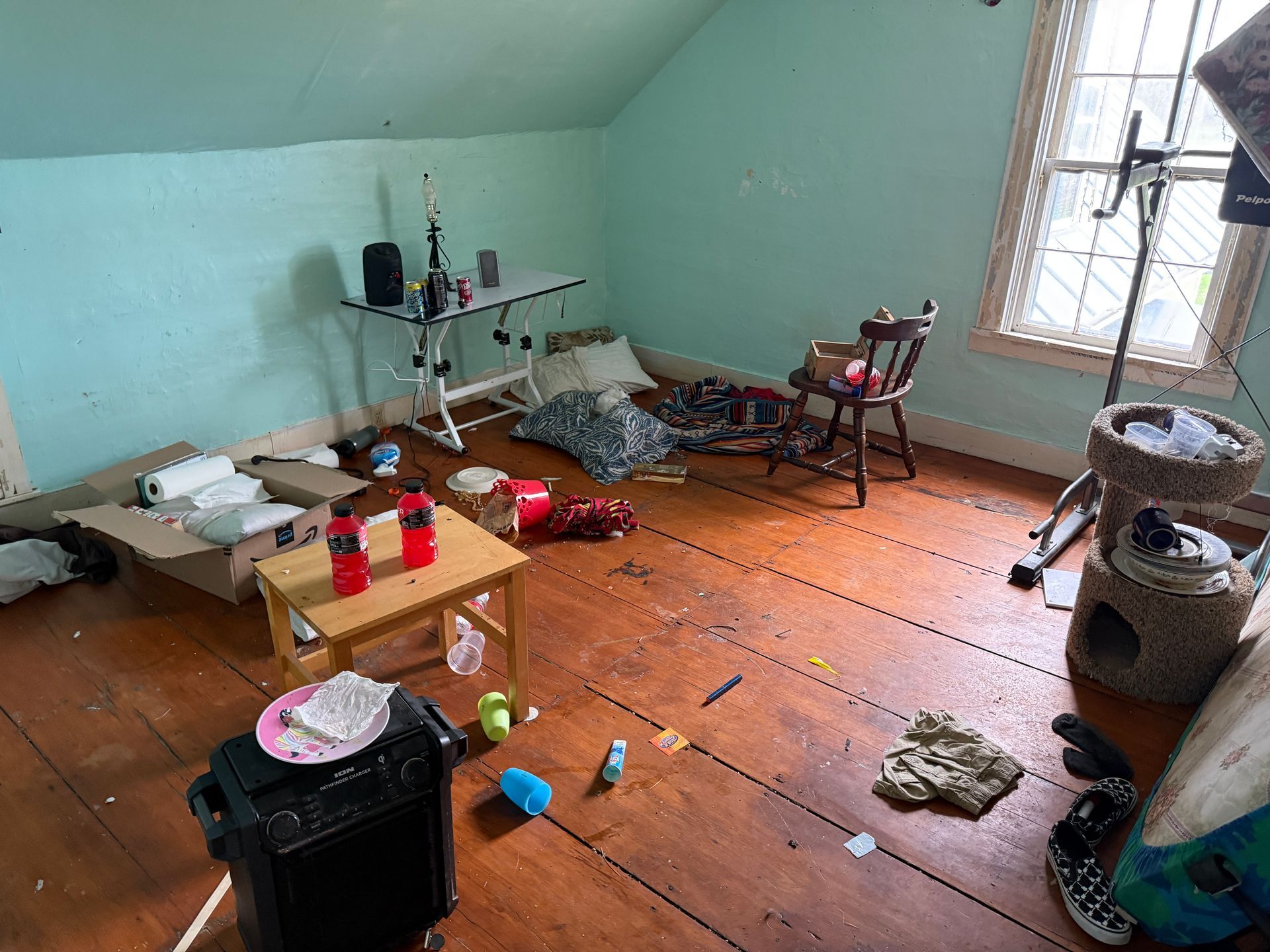 Room with wooden floors, blue walls, a small table, boxes.