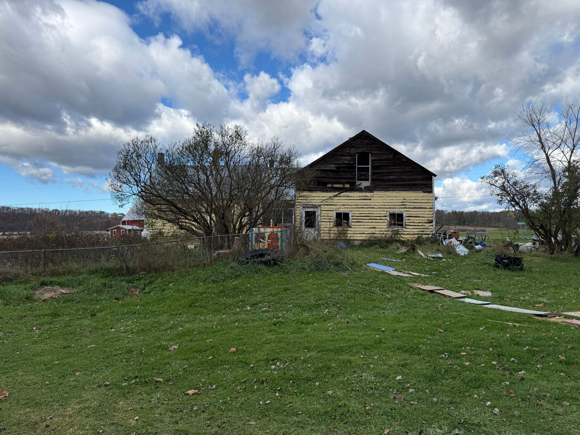 Wooden building under a partly cloudy sky, surrounded by green grass.
