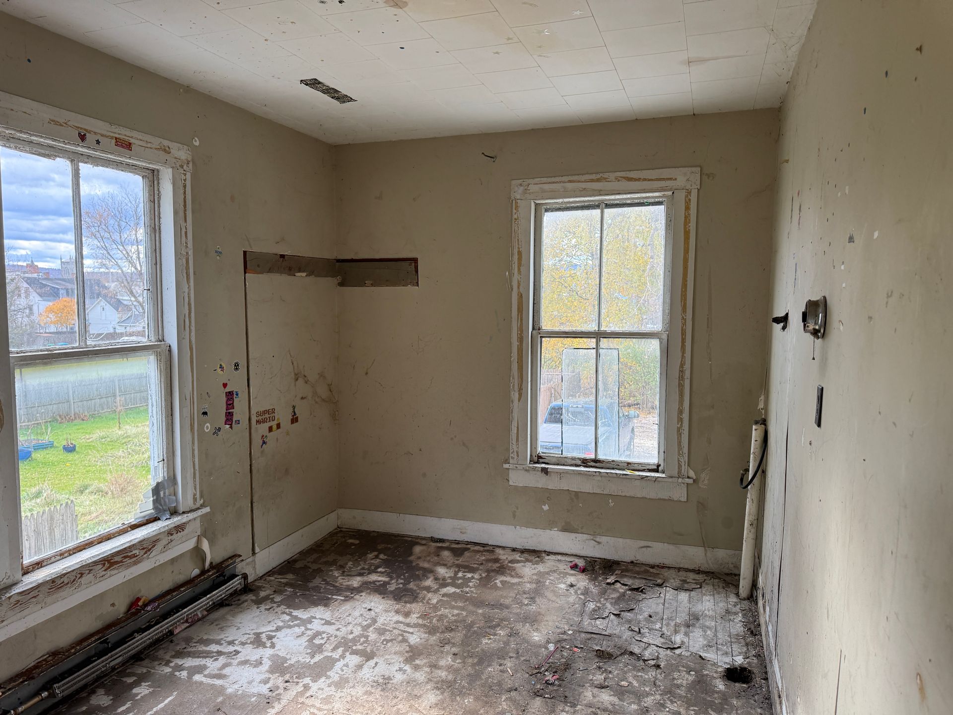 Room with two windows, walls, and floor.