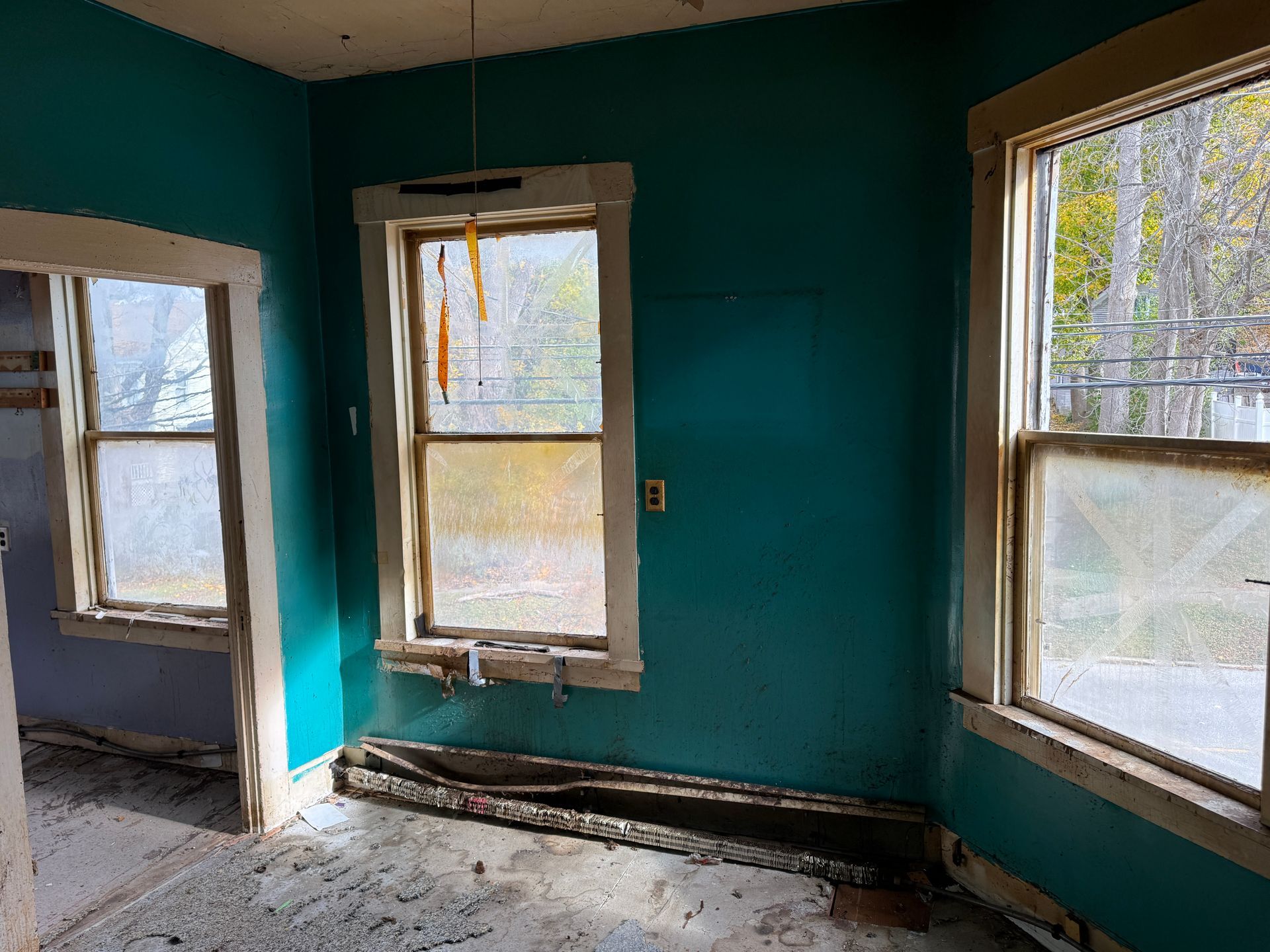 Interior of a room with turquoise walls, windows, and trim.