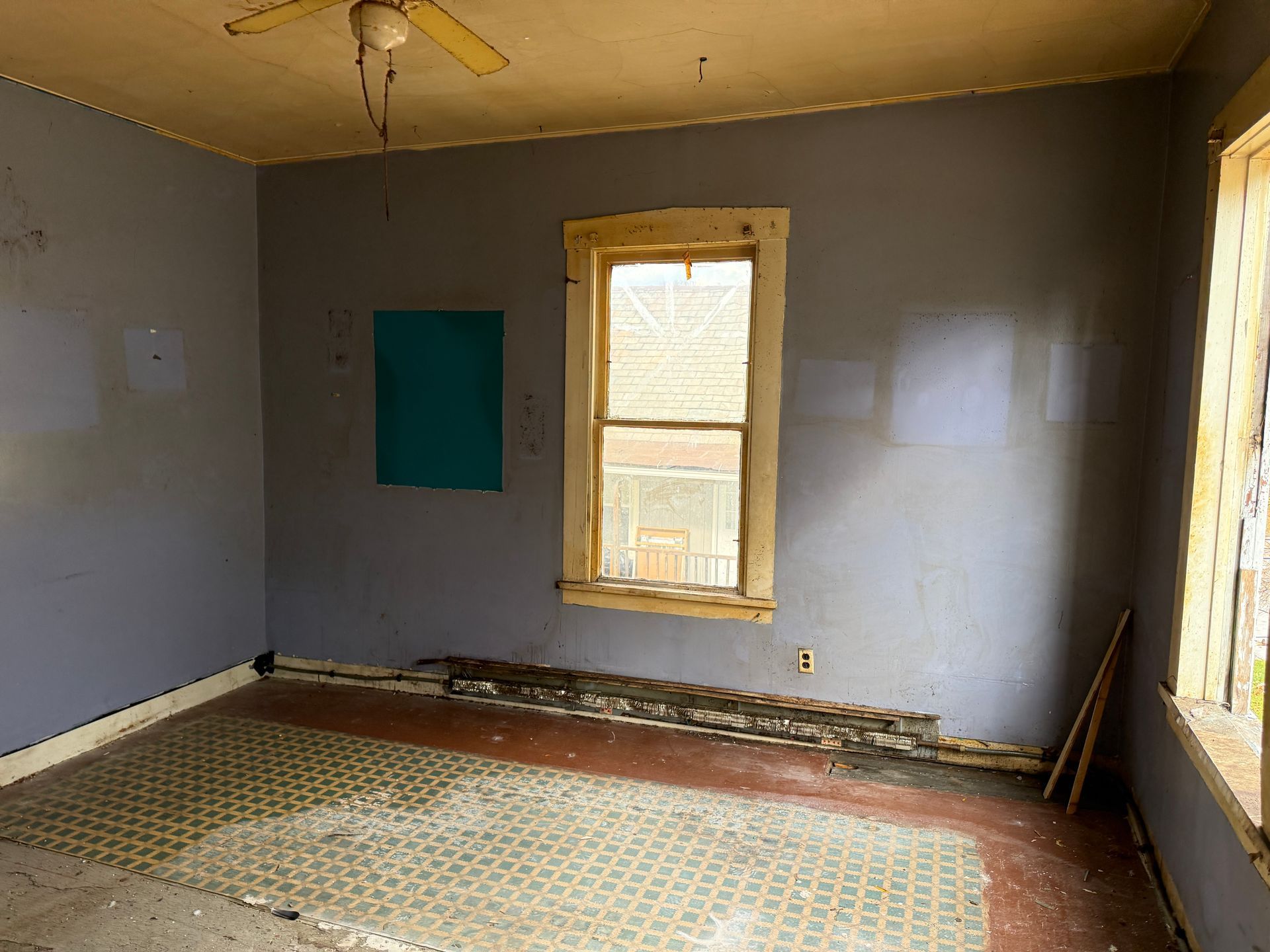 Empty room with paint, a window, and flooring. Blue walls and beige ceiling.