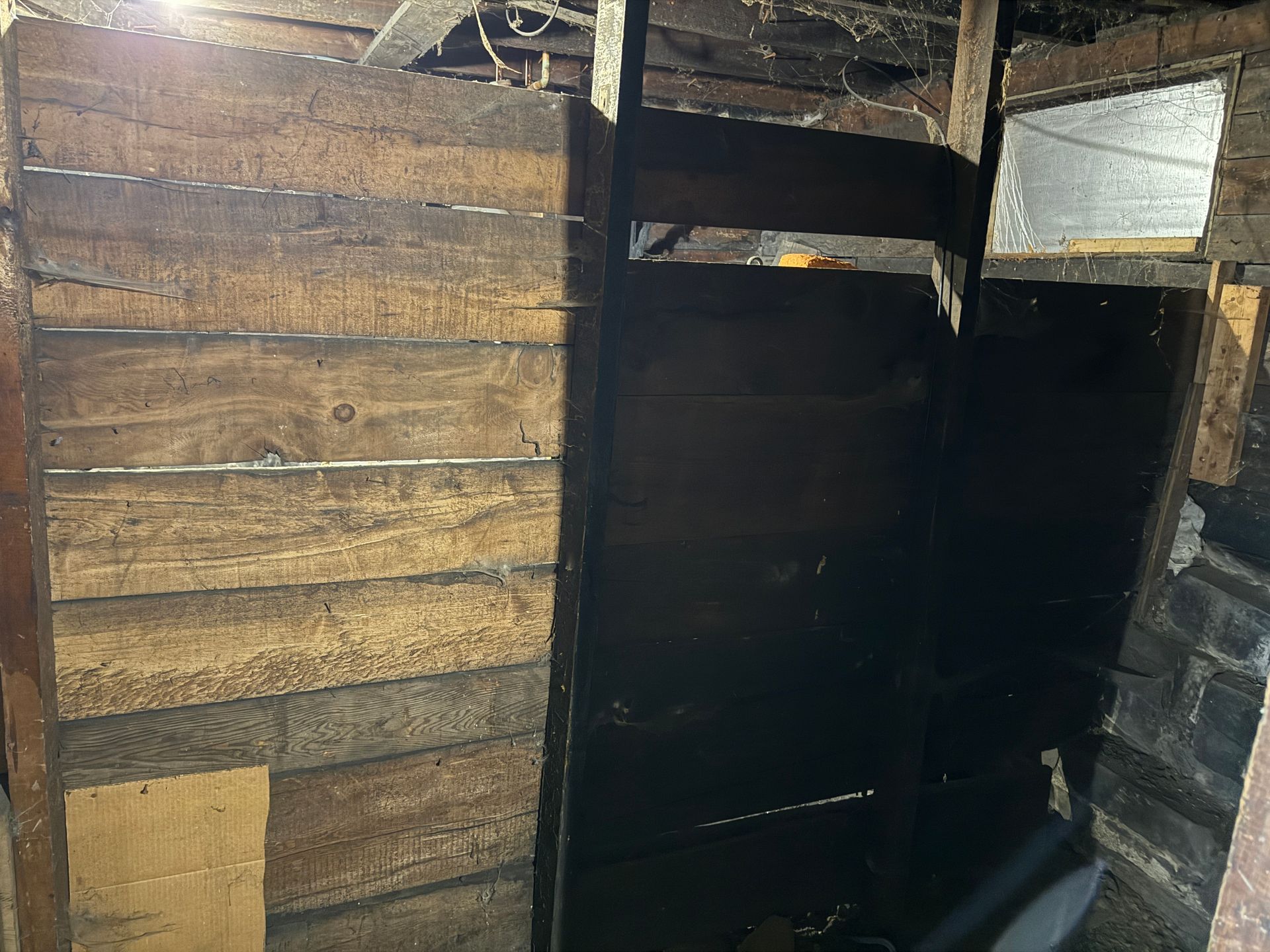 Interior view of a narrow space with wood planks, possibly a closet or storage area.