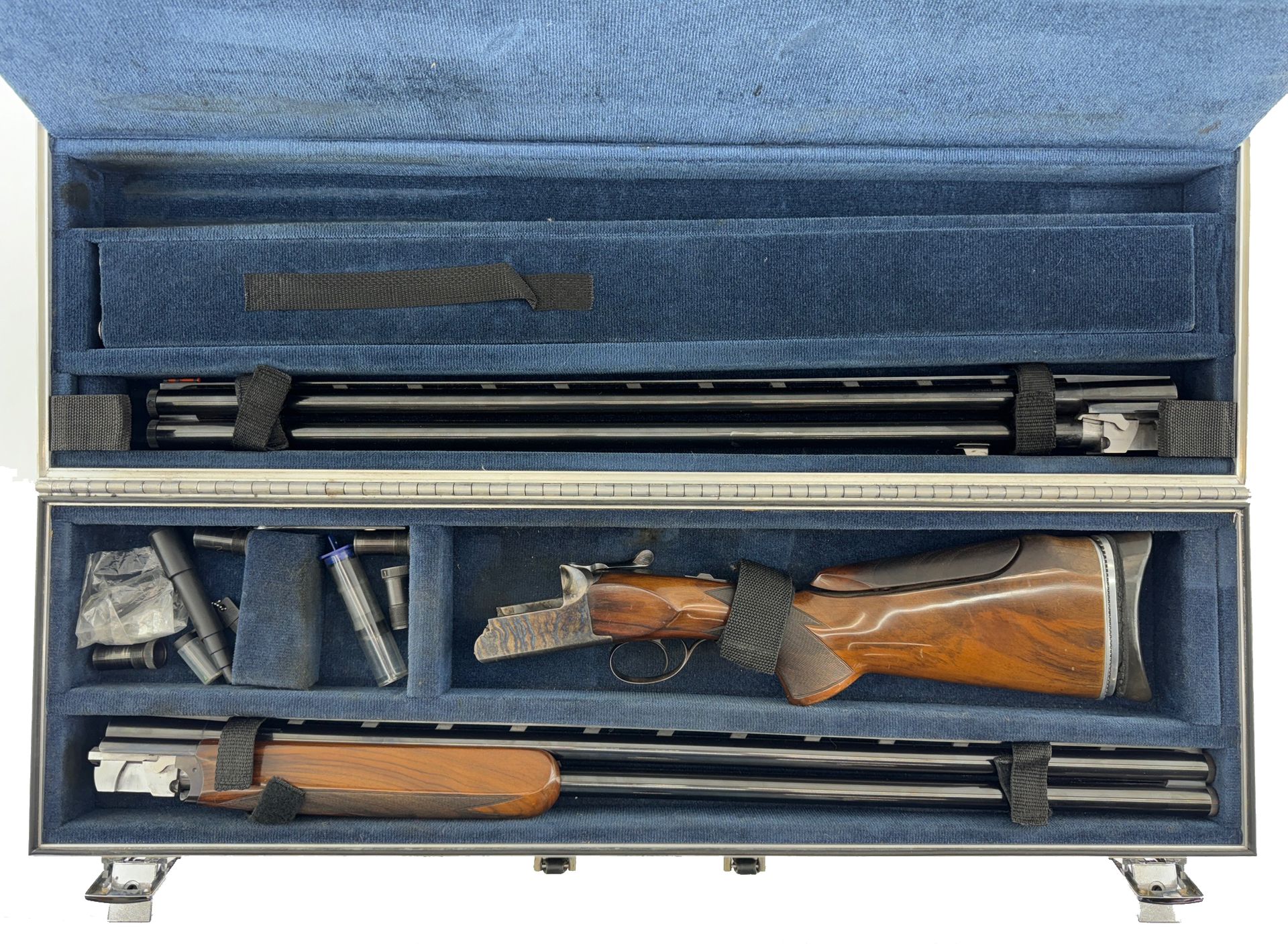 Shotgun parts neatly arranged in a silver case with blue lining.