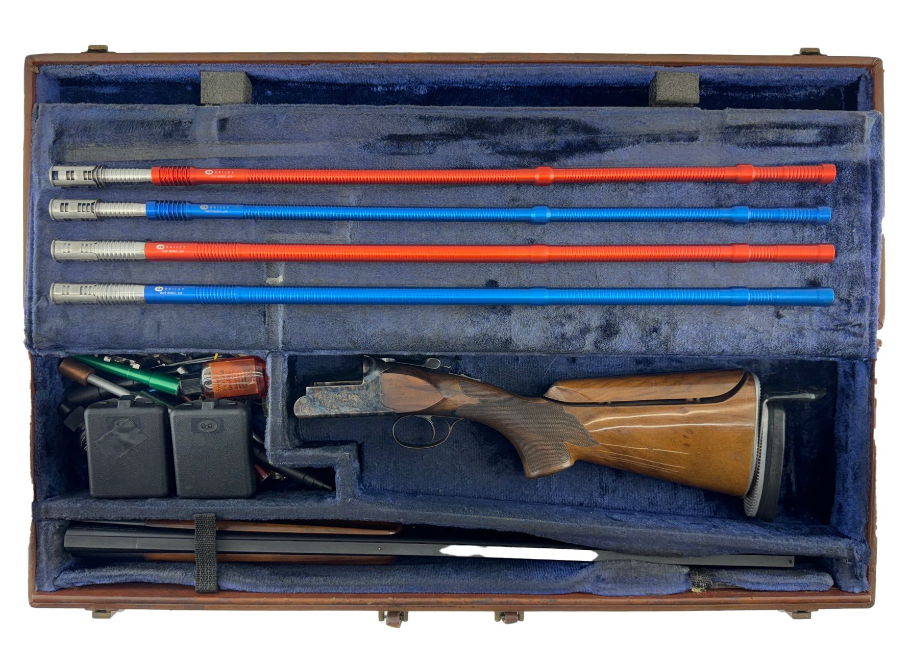 Open, brown rifle case with disassembled parts. Blue and red rods, wooden stock.