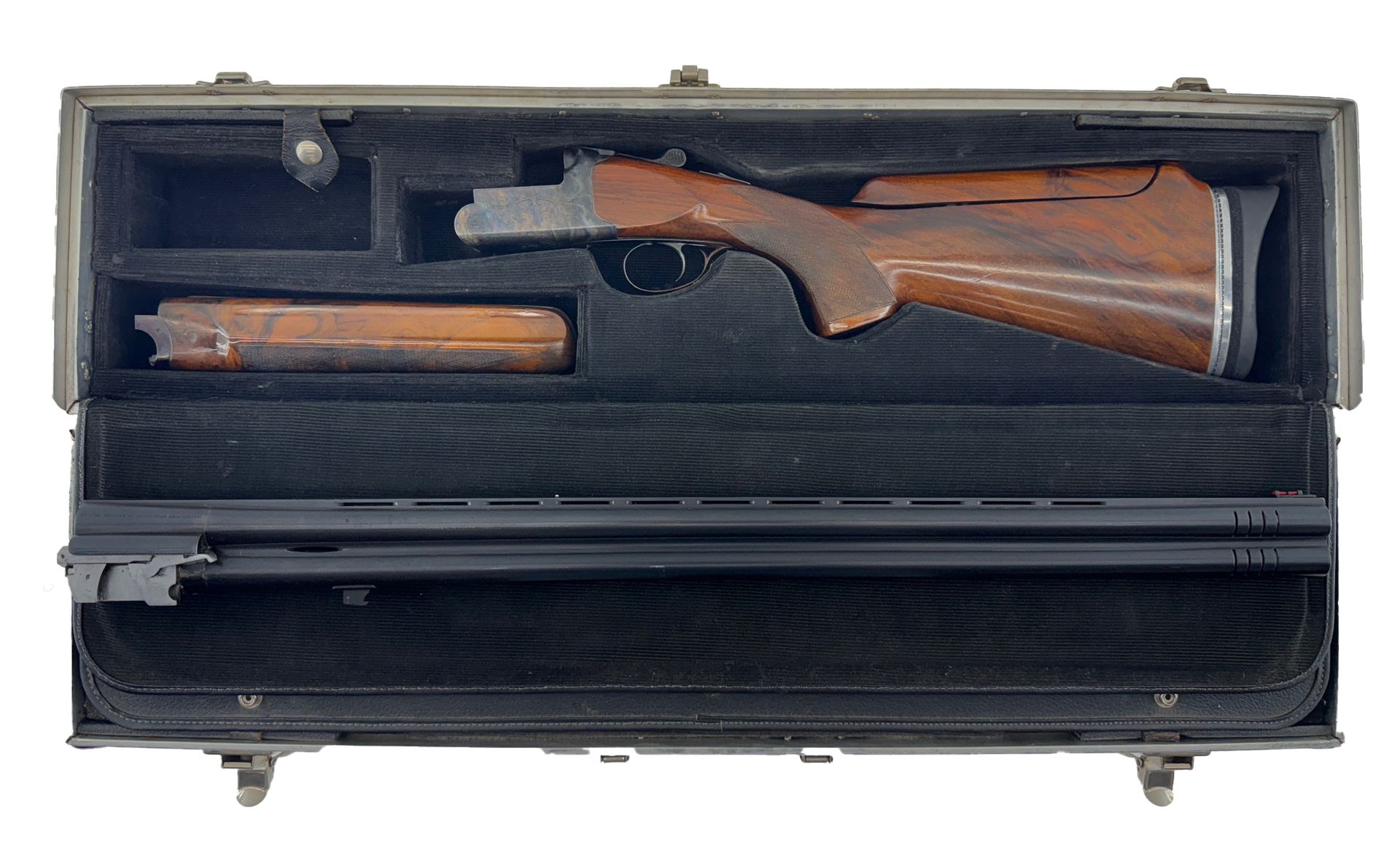 Open gun case containing a disassembled shotgun. Wooden stock and barrel visible, black interior.