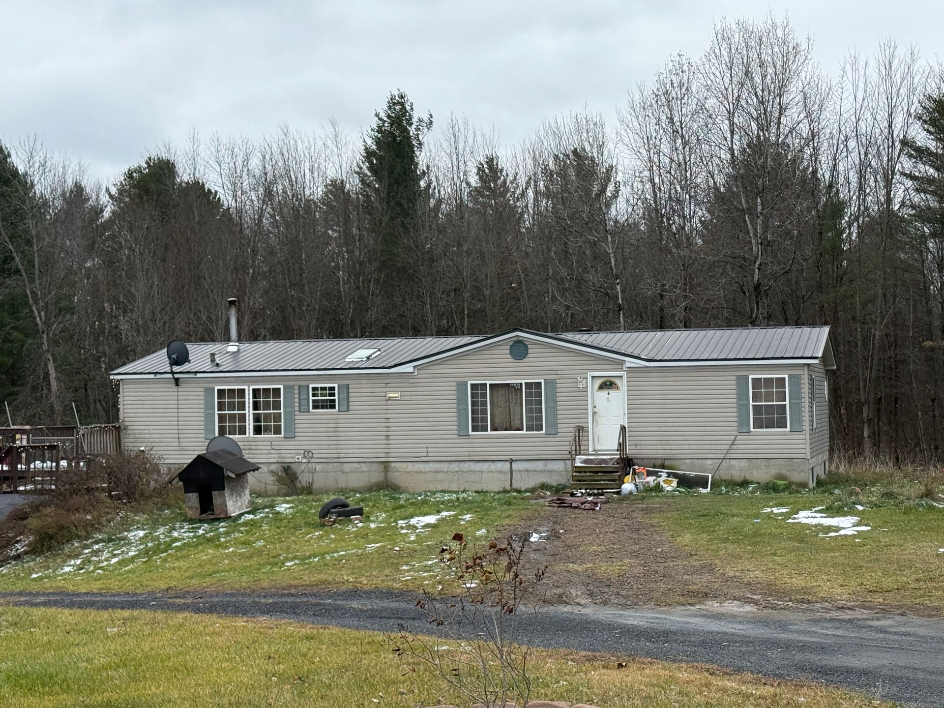 beige mobile home in a rural clearing