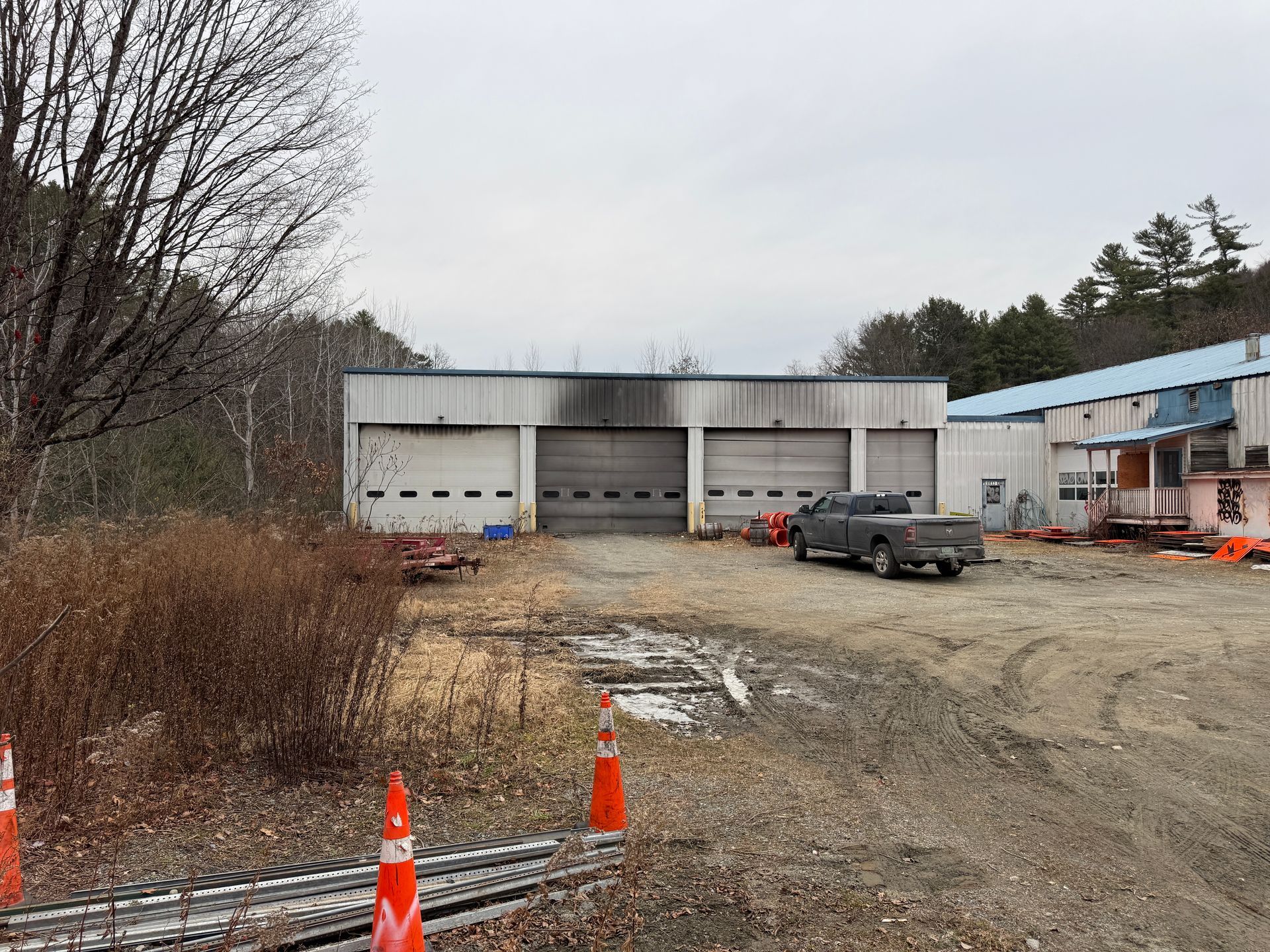 A gray building with three garage doors.