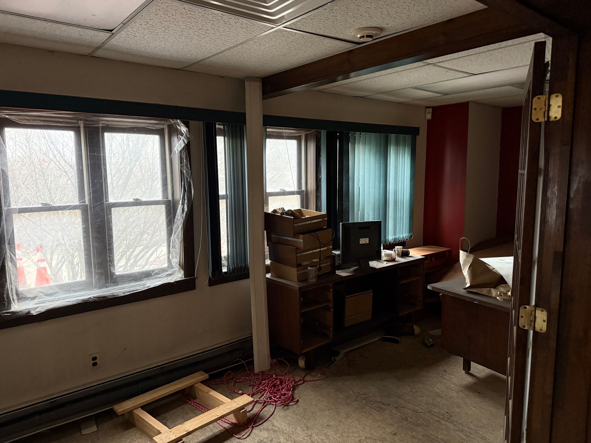 Interior room with two windows, desk, and miscellaneous items; walls are painted white and red.