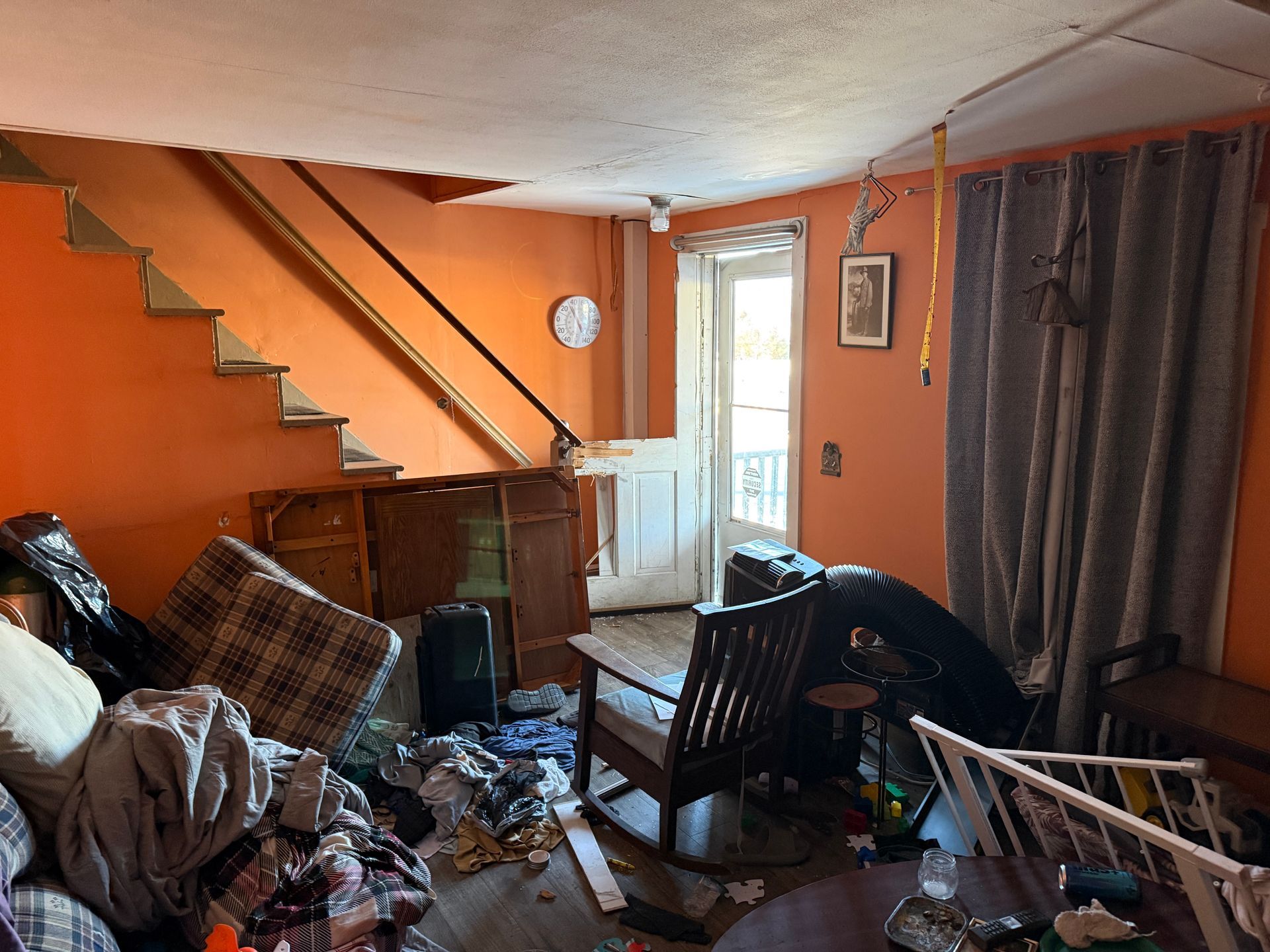 Interior with orange walls, stairs. Includes rocking chair, door, and furniture.