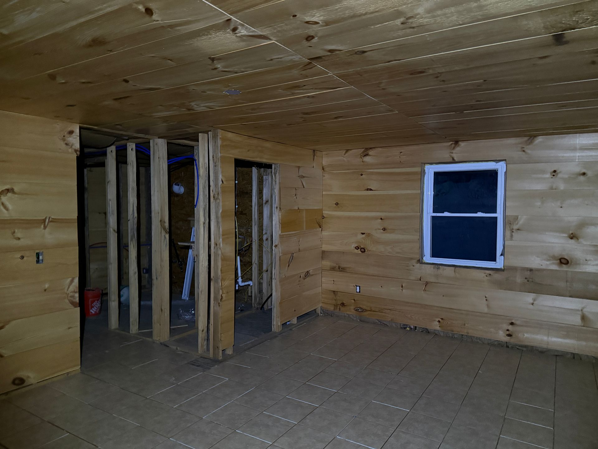Interior of a room with unfinished wooden walls, ceiling, and floor.