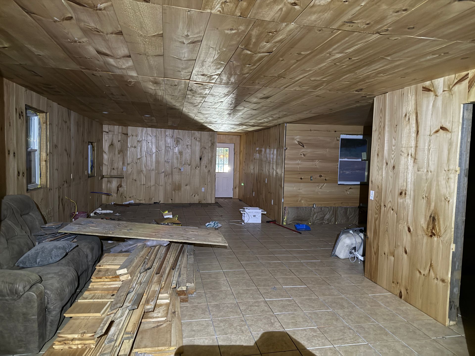 Interior of a room with wooden paneling on walls and ceiling.