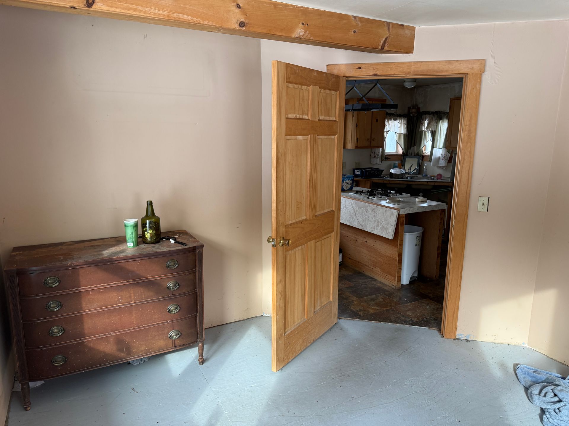 Open doorway leads to kitchen. A dresser sits to the left.